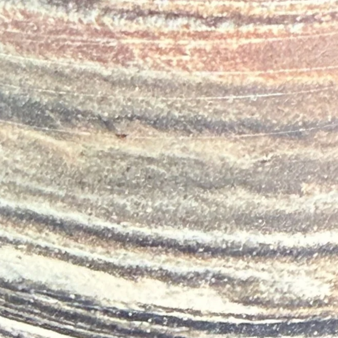 Close-up of ceramic surface with visible grain and texture.