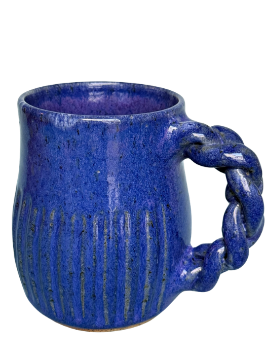 A blue ceramic mug with a textured surface and a twisted handle.