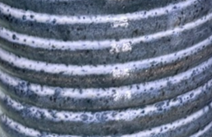 Close-up of a metallic coil or spring with a weathered surface.