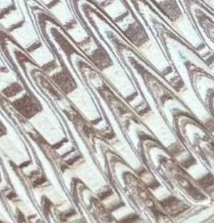 Close-up of a metallic or reflective surface with diagonal, parallel lines.