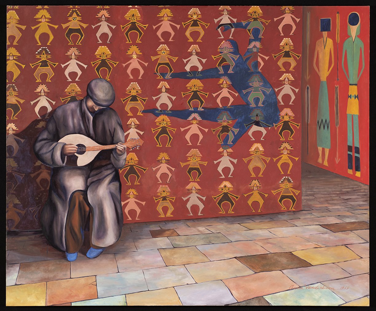 A mural mural depicts a seated man in traditional clothing playing a stringed instrument in front of a vibrant patterned backdrop with stylized human figures in red, yellow, black, and pink. To the right, a corner of another wall features two tall, elongated figures with spear and shield on a red background.
