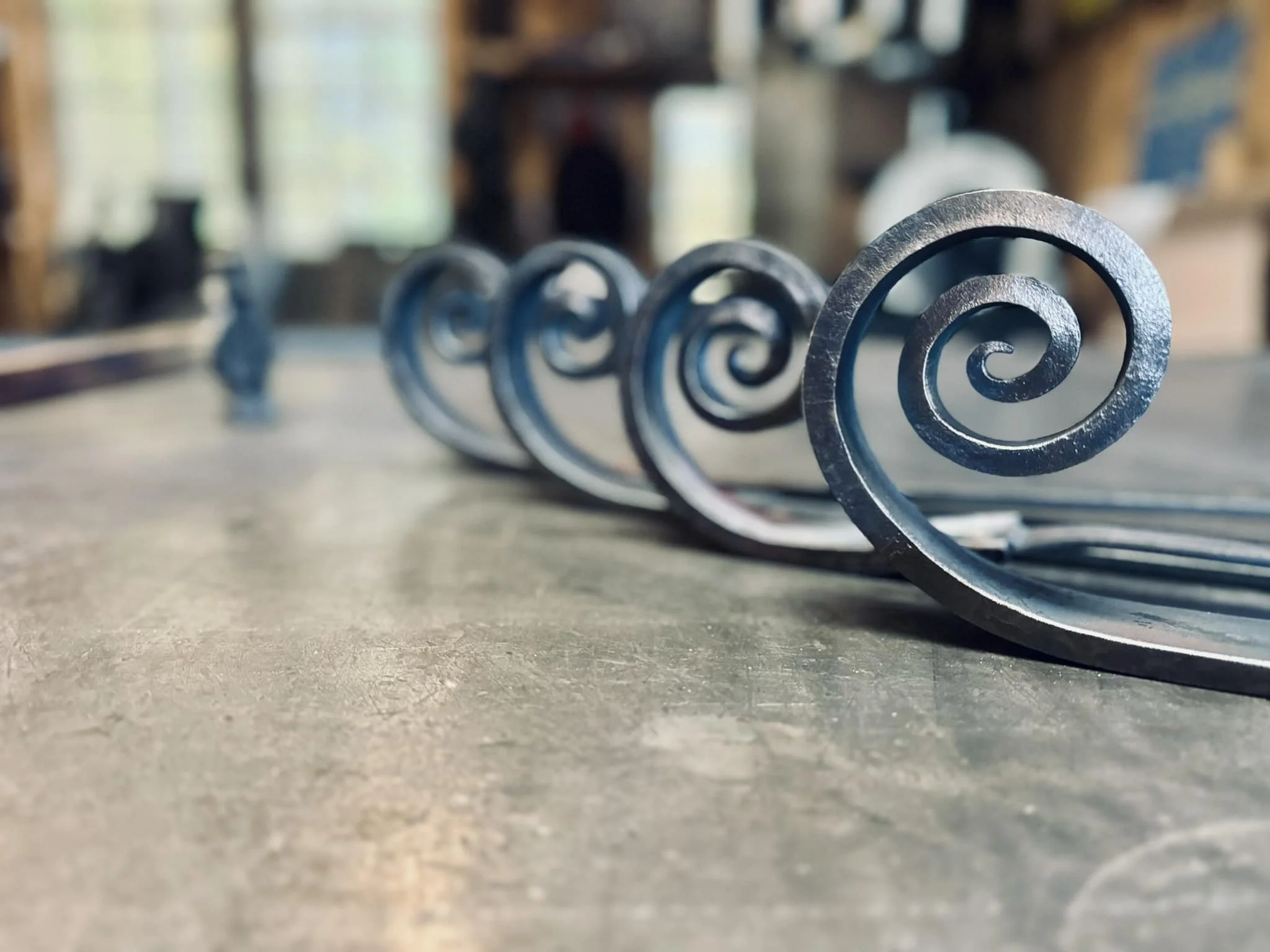 Line of metal springs on a concrete floor in a workshop or garage.