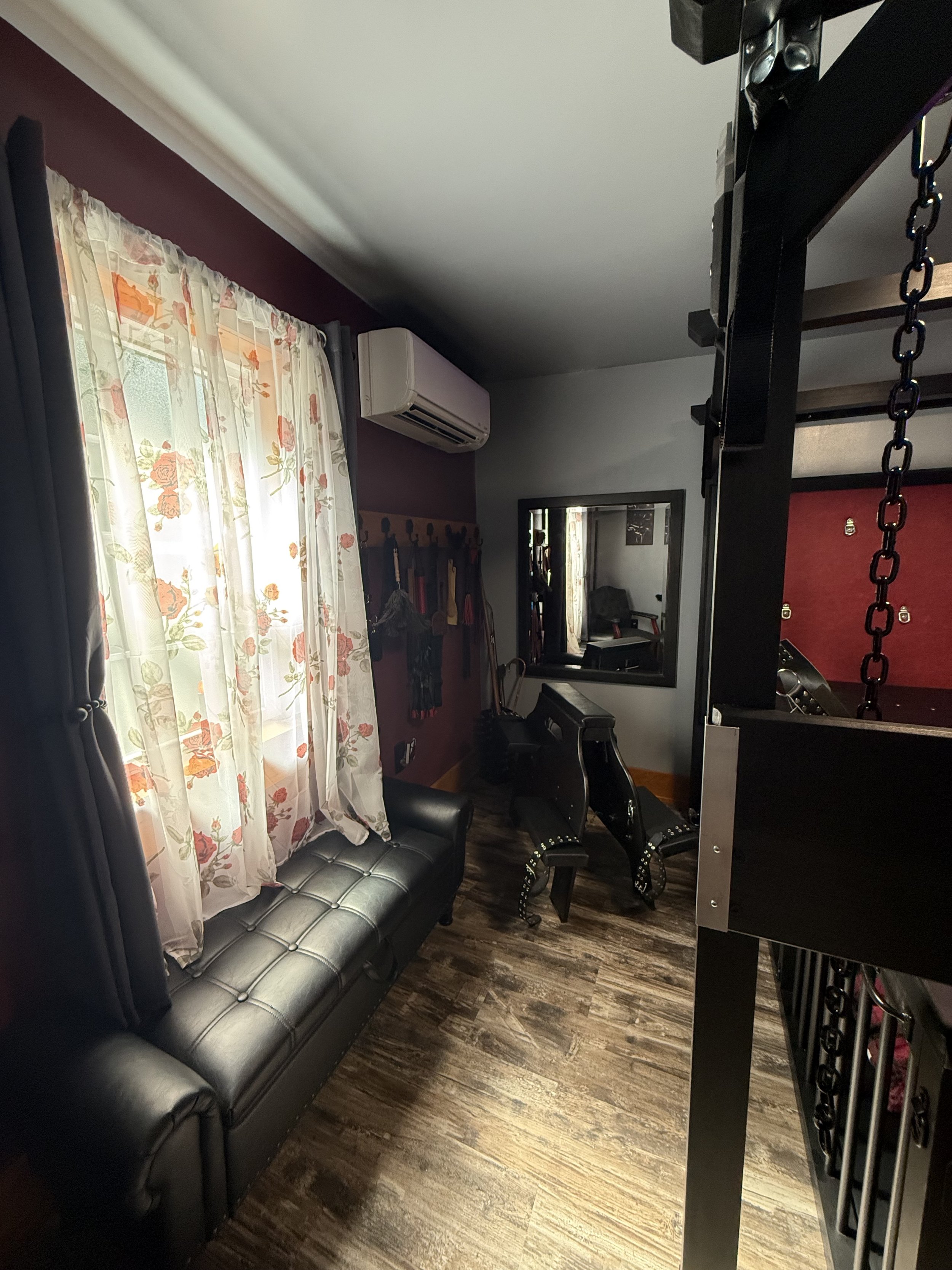  black leather tufted bench along a wall, a mirror, chairs, and prayer bench