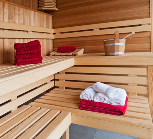 Sauna, jossa on pyyhkeitä ja kiulu.