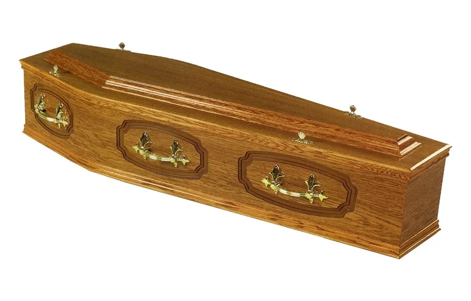 A wooden coffin with decorative brass handles and carved details.