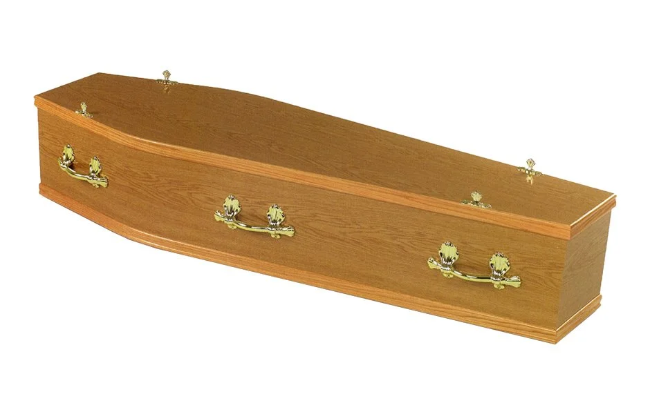A wooden coffin with gold-colored handles and decorative hardware.