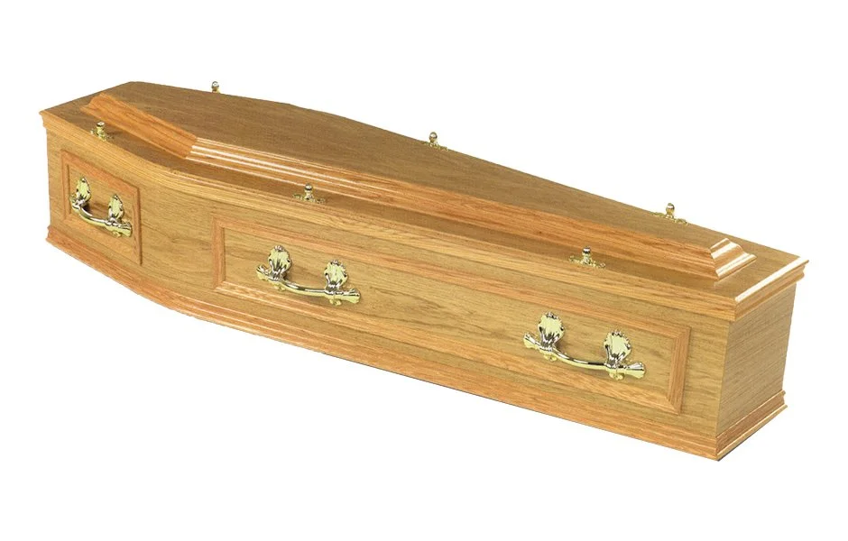 A wooden coffin with gold handles and decorative elements.