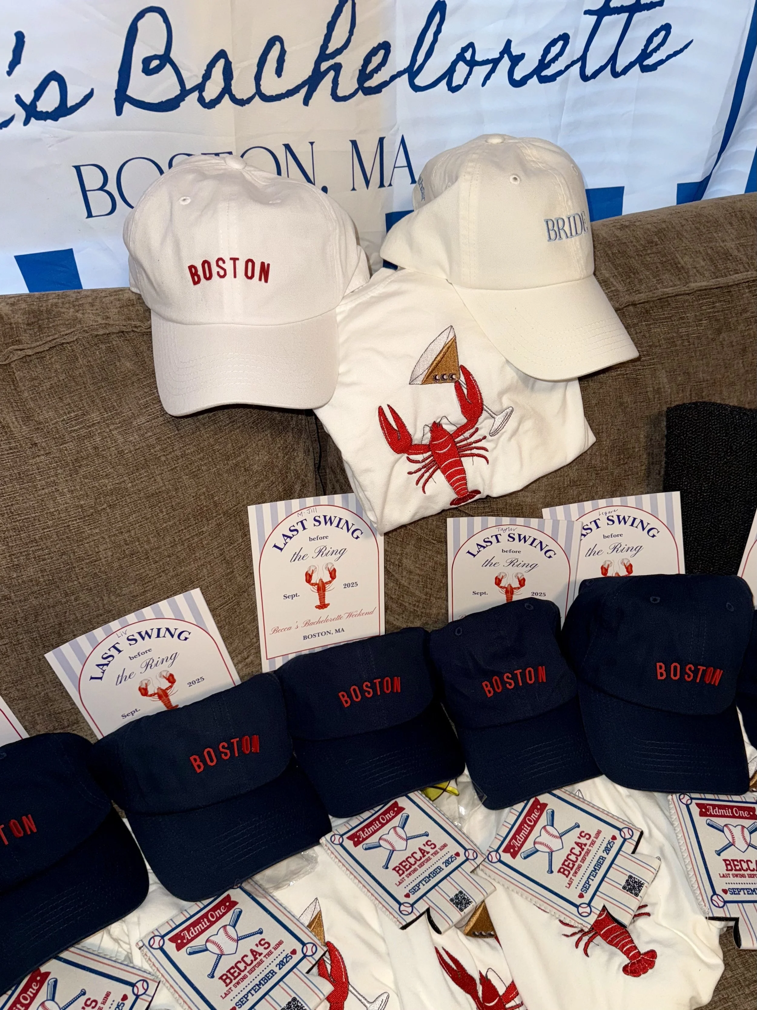 Various white and black baseball caps with red and blue embroidery, some with the word Boston and some with Bride, alongside event flyers for a baseball-themed party in Boston, Massachusetts, for September 2025.