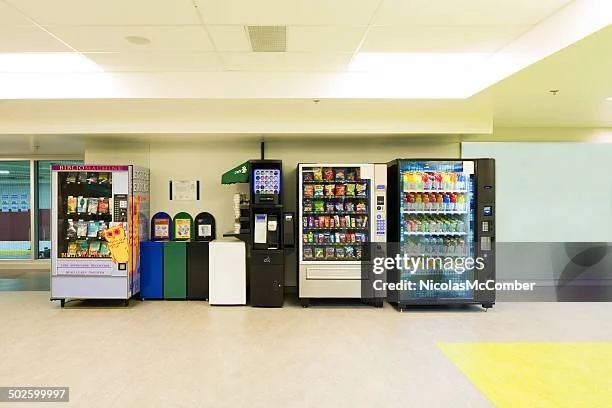 Row of vending machines selling snacks and beverages in an indoor setting.