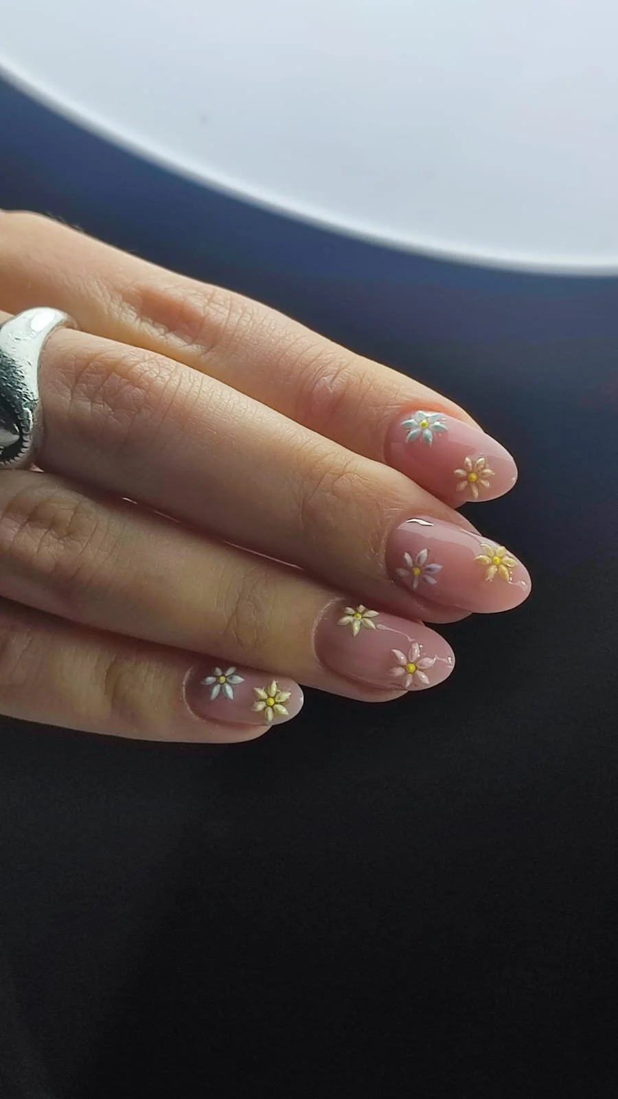 Unghie con smalto rosa chiaro e decorazioni di fiori bianchi e gialli