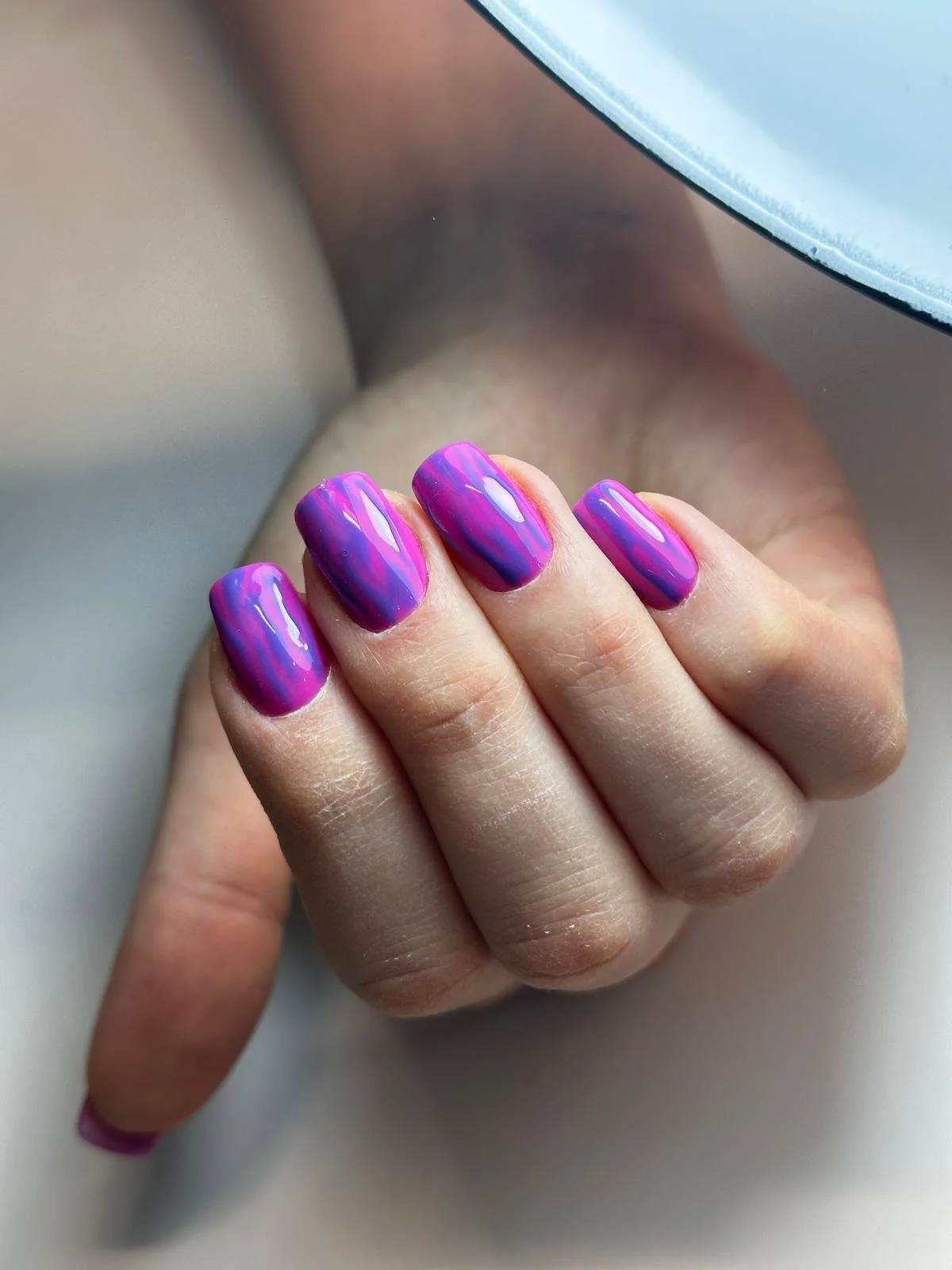 Unghie con smalto viola e viola sfumato, riflessi lucidi e stile marbled.