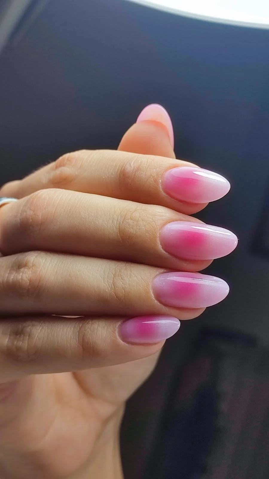 Un dito con un' unghia dipinta di rosa con sfumature bianche