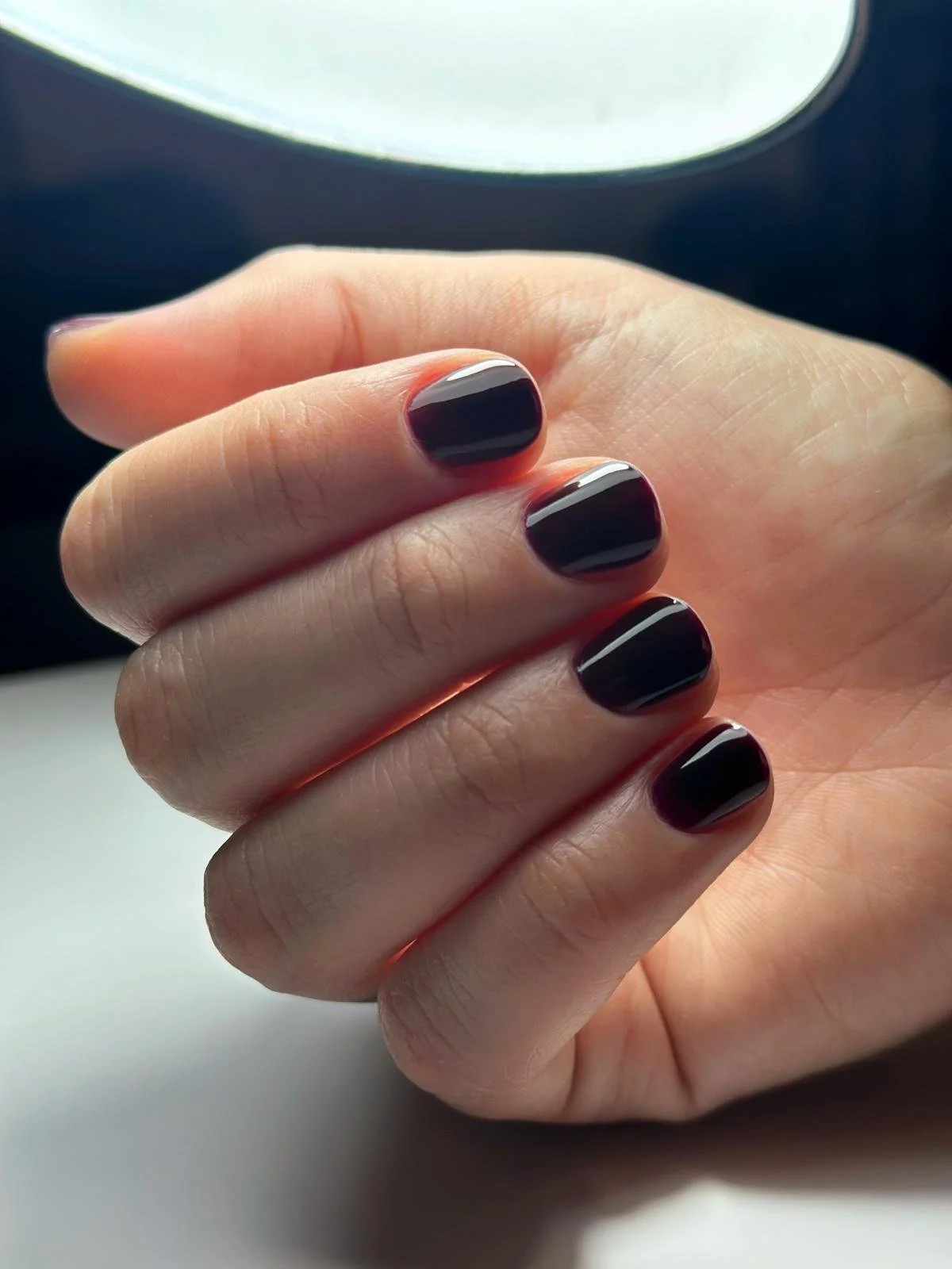 Unghia dipinta di nero con linee sottili dorate.