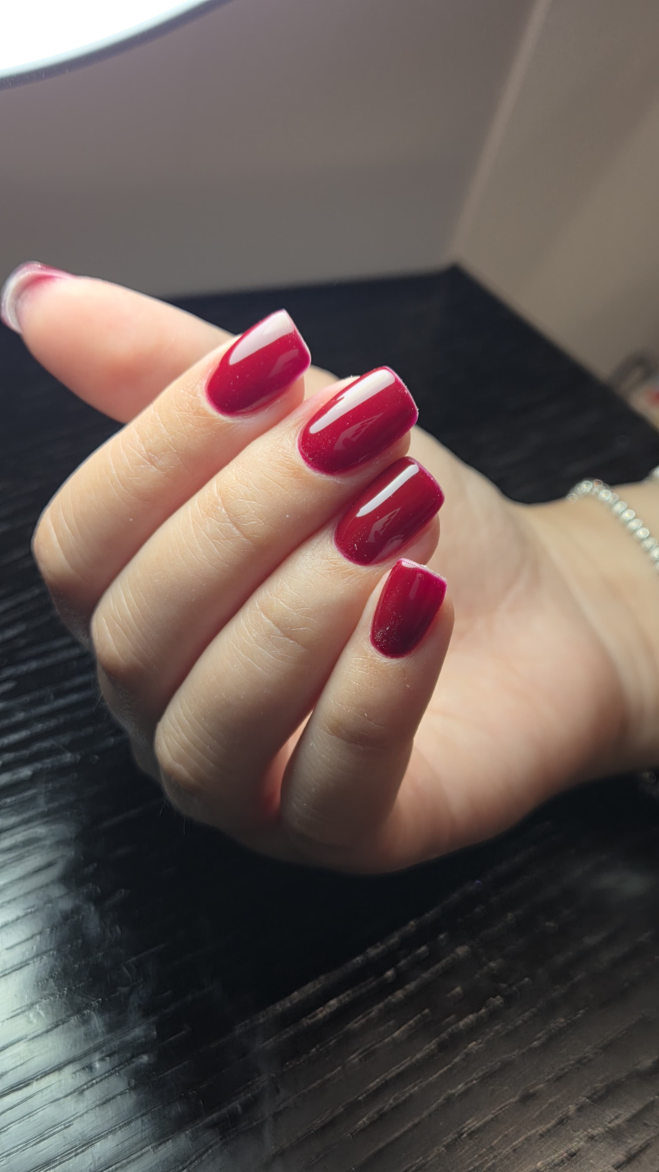 Un dito con un'unghia rosso brillante.