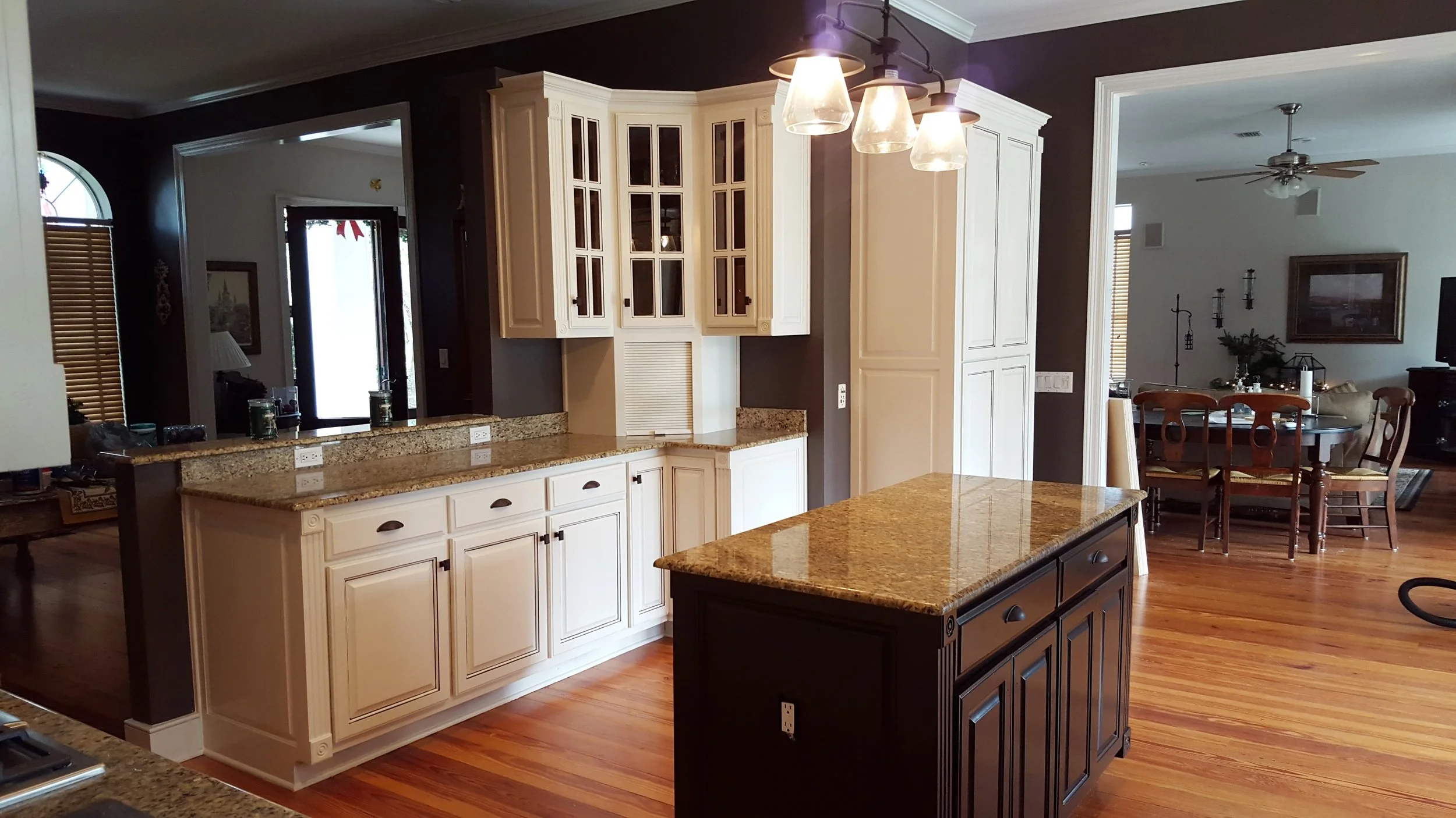 Restained kitchen cabinets and kitchen island with repainted walls and accents.