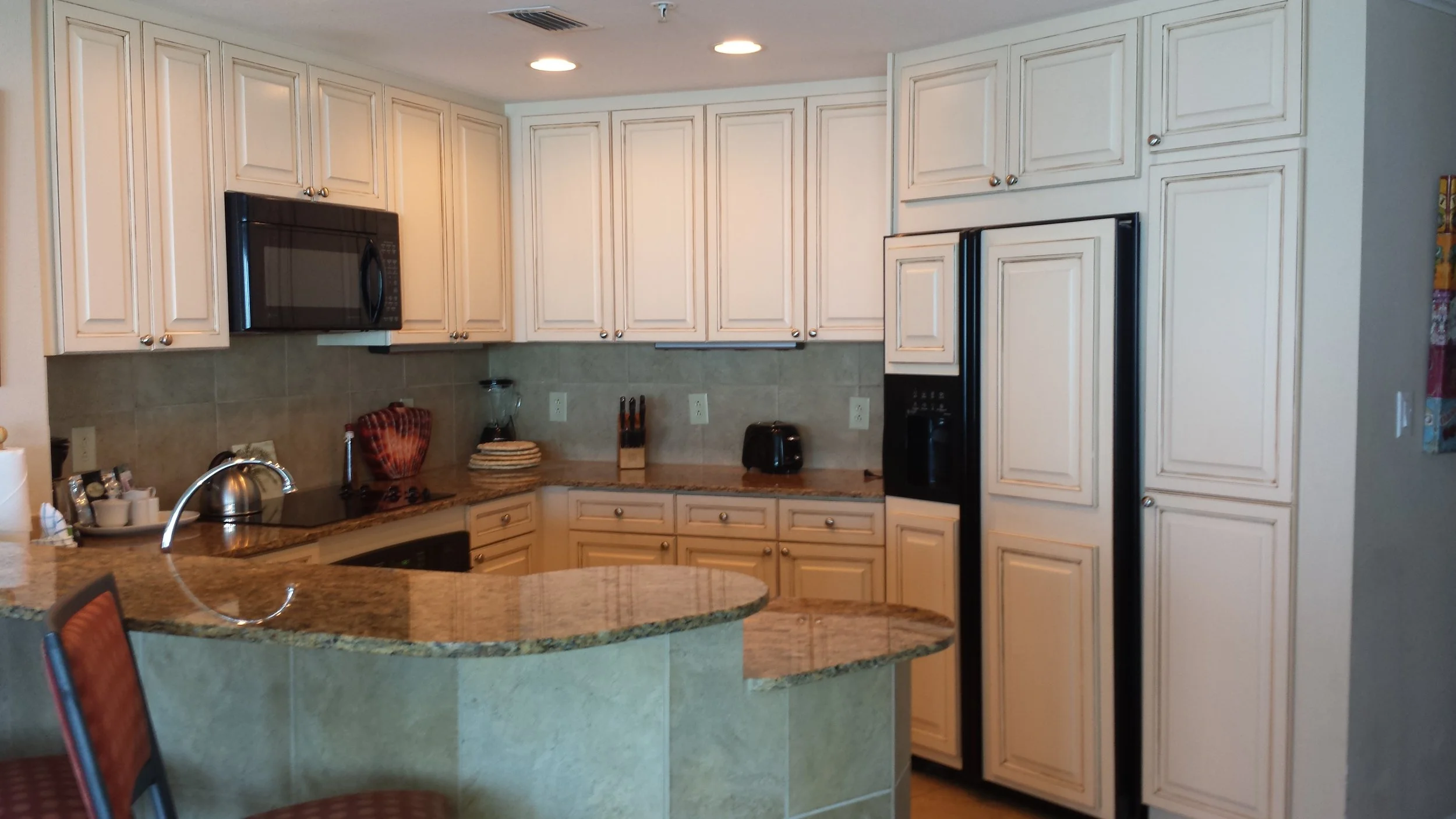 Refinished cabinets with faux finish "Antiquing" to match refrigerator design.
