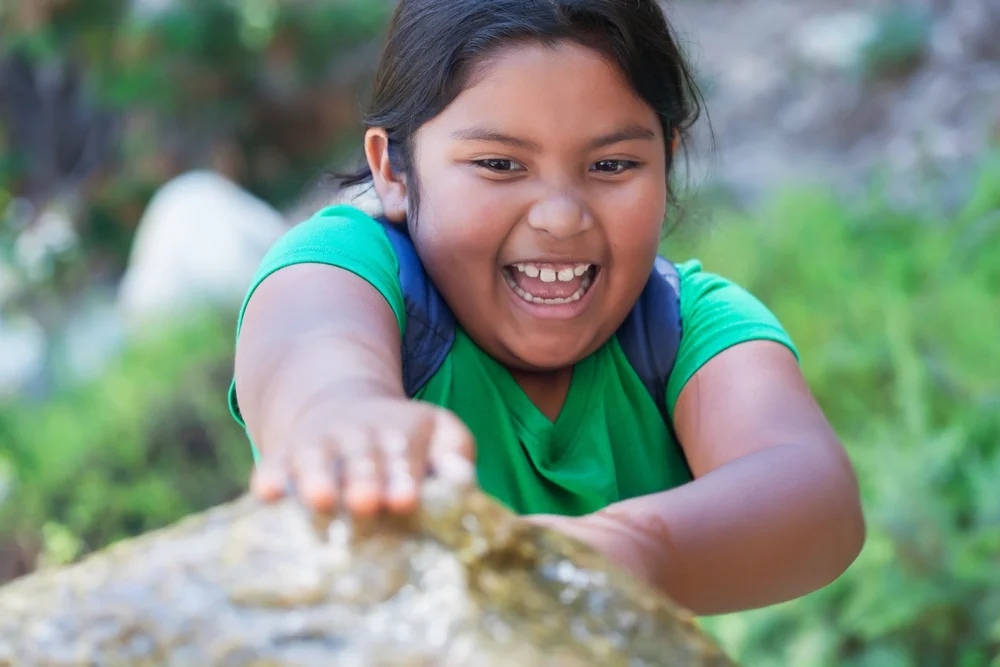 Girl climbing a rock outdoors