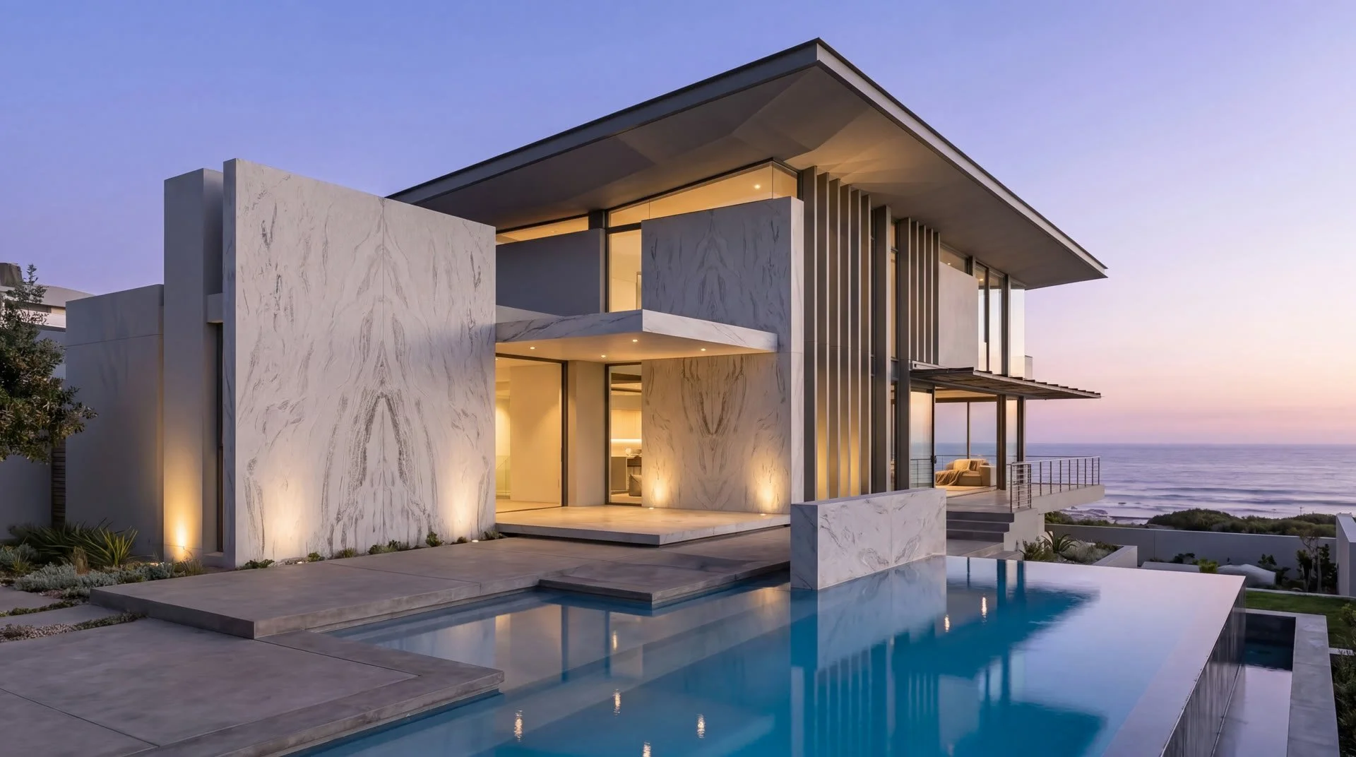Modern home exterior at dusk with natural stone facade and pool