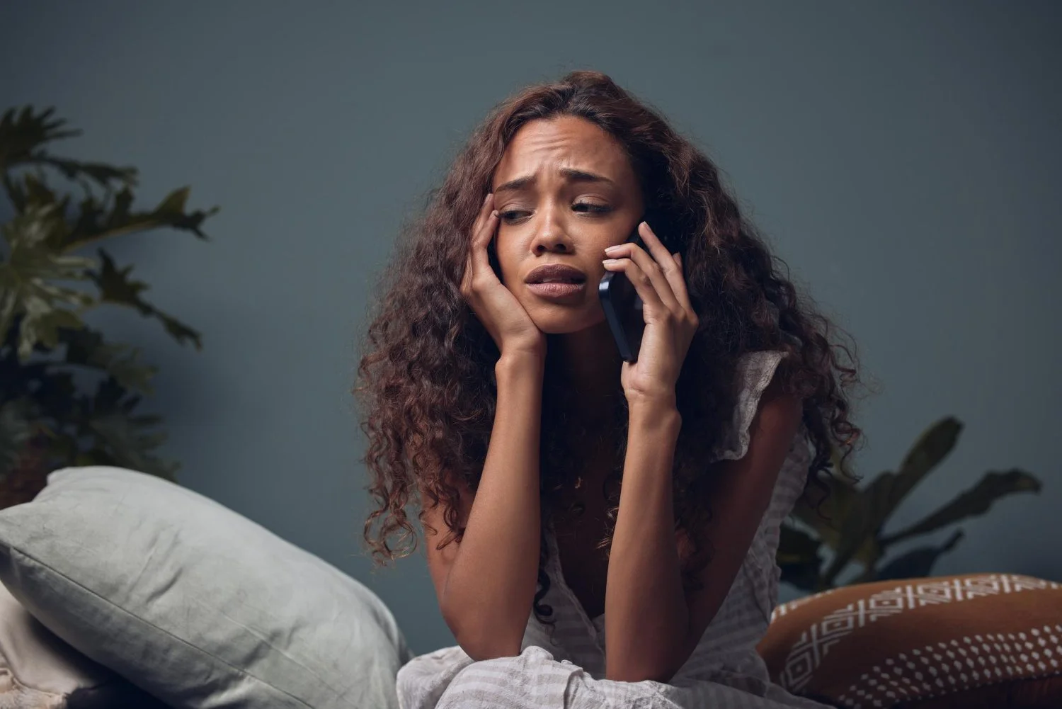 Distressed person on phone, representing coercive control, fear, or emotional manipulation