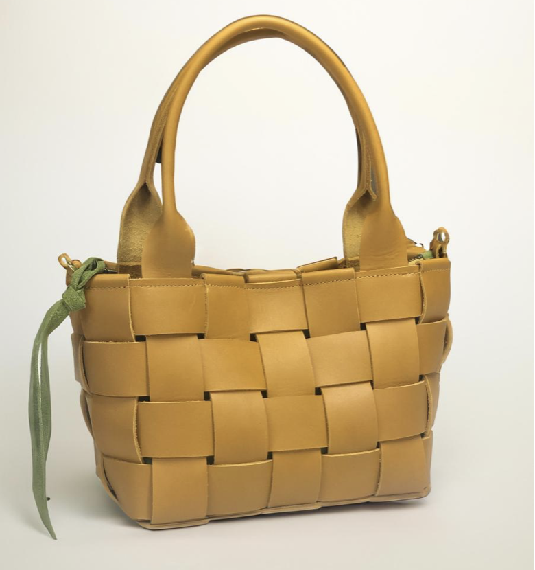 Bubo Handmade - A mustard yellow woven leather handbag with two handles and a green ribbon tied to the side handle.