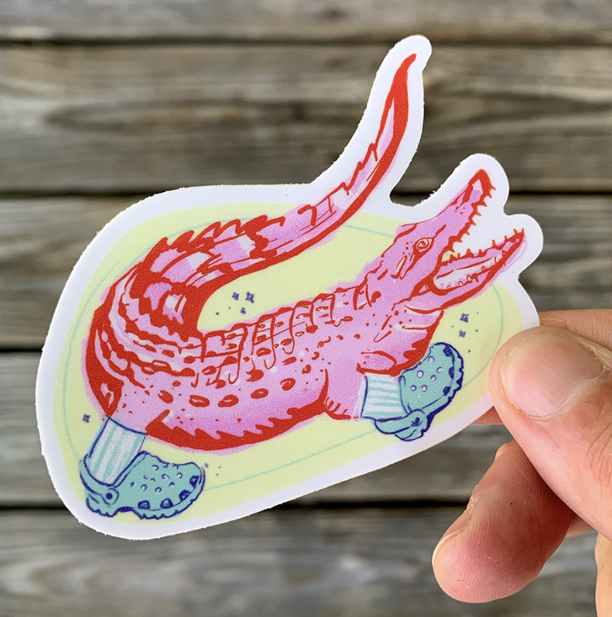 Colorful sticker of a crocodile or alligator with socks, holding a golf club, in a cartoon style.