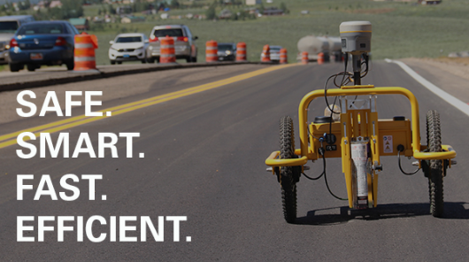 A yellow autonomous road maintenance vehicle on a highway with orange traffic barrels and multiple cars in the background, and text reading 'SAFE. SMART. FAST. EFFICIENT.'