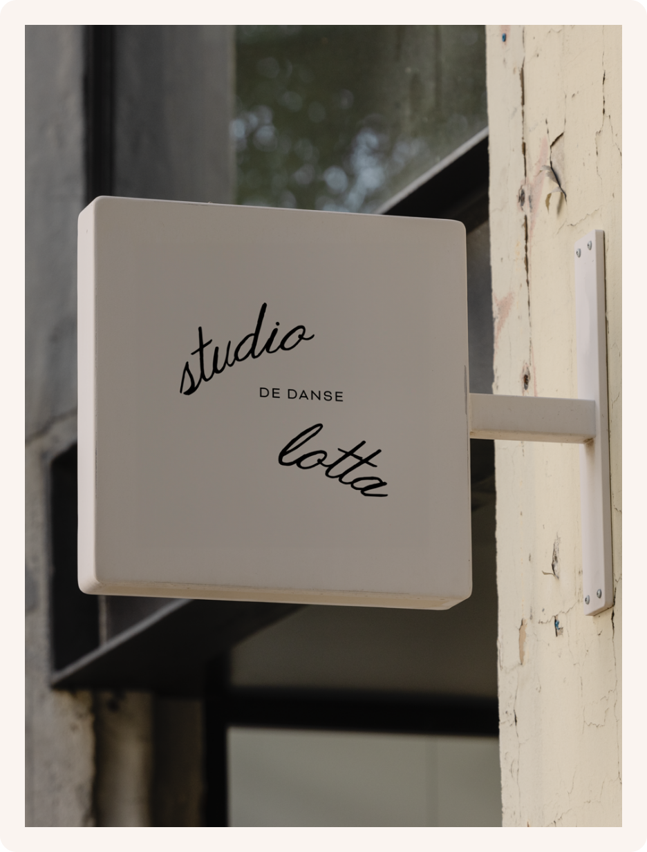 Signboard reading 'studio de danse Lotta' mounted on an exterior wall.