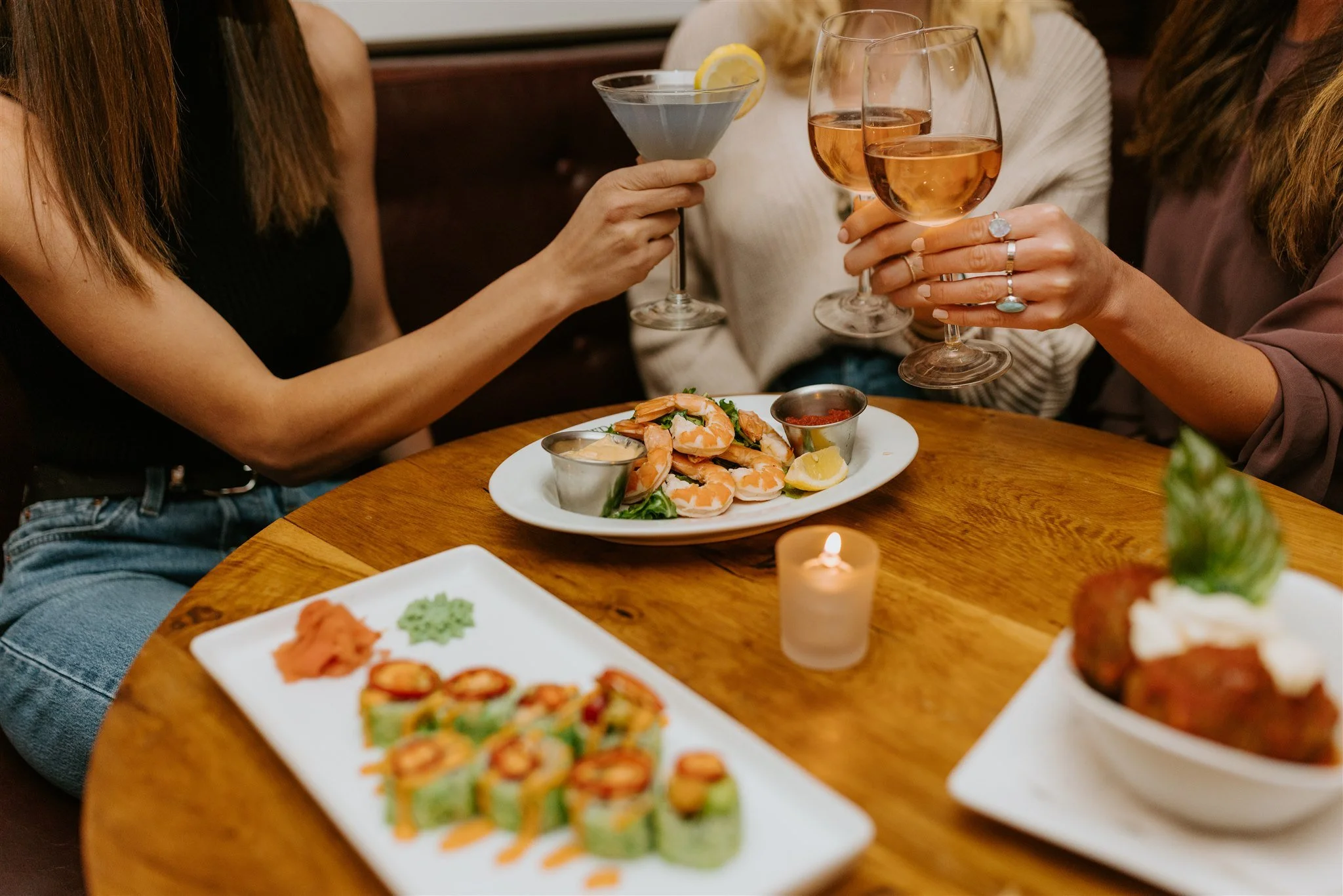 Three women having a toast and a meal together at the restaurant