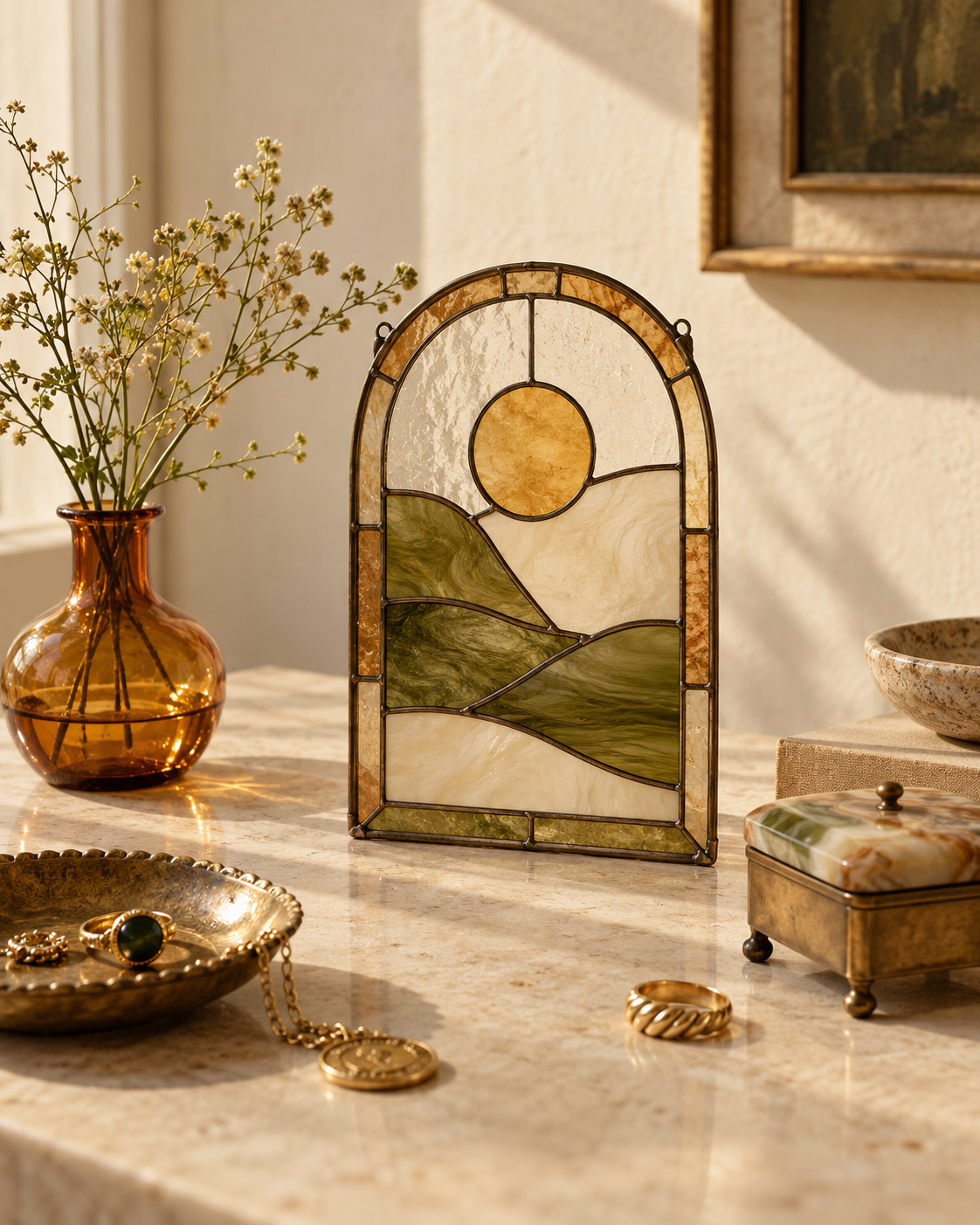 Decorative table with a stained glass landscape scene, a vase with flowers, and jewelry including rings and a necklace.