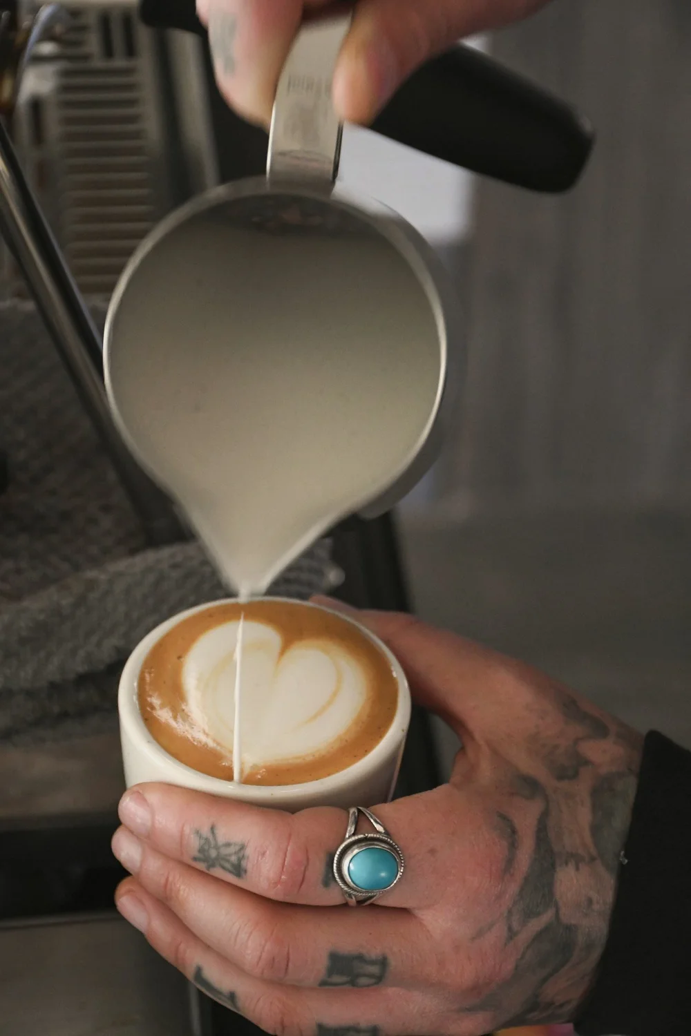 Barista pouring a latte at a Street Coffee Collective mobile espresso bar