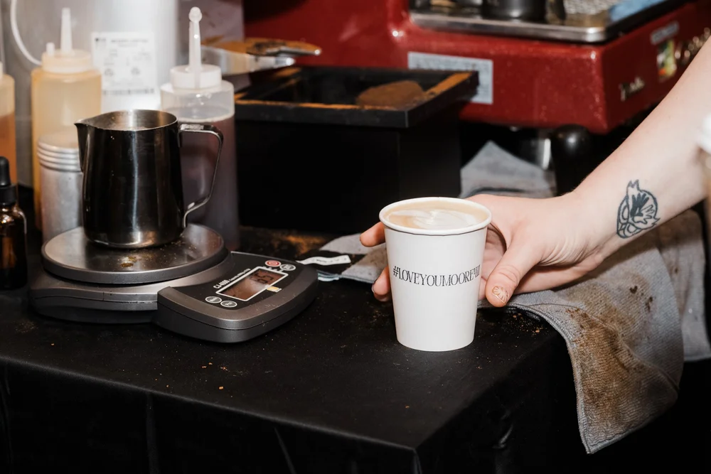Street Coffee Collective serving a branded coffee at a mobile espresso bar