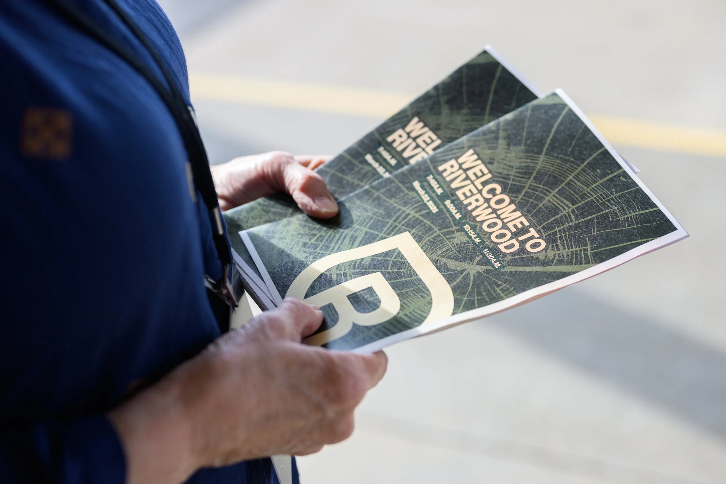 Person holding flyer with a map and the text 'Welcome to Welcomewood' printed on it.