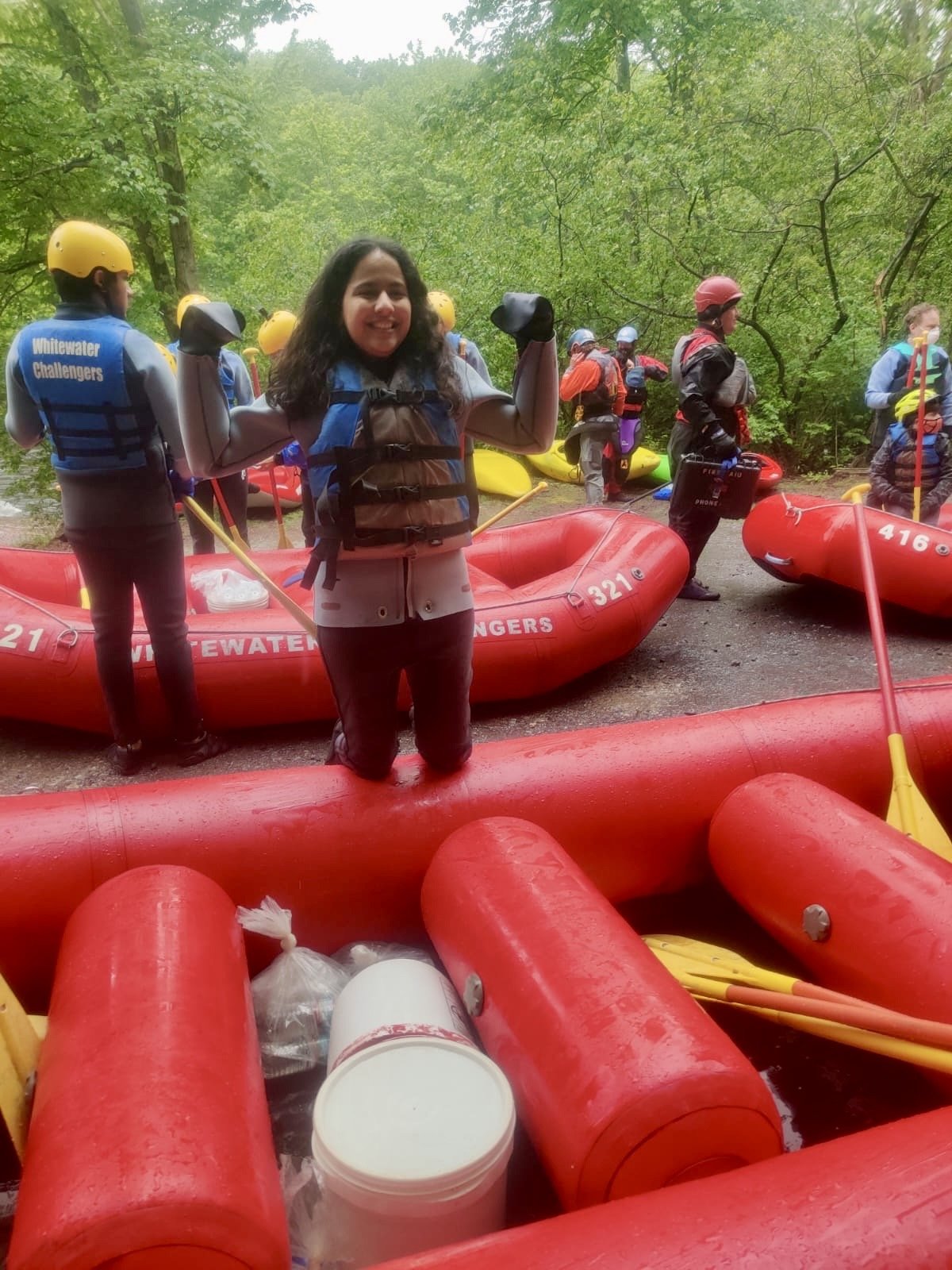 Akanksha Rathod, Founder of Nee's Physical Therapy Hoboken preparing for white water rafting in a forested area with inflatable boats, paddles, and safety gear.