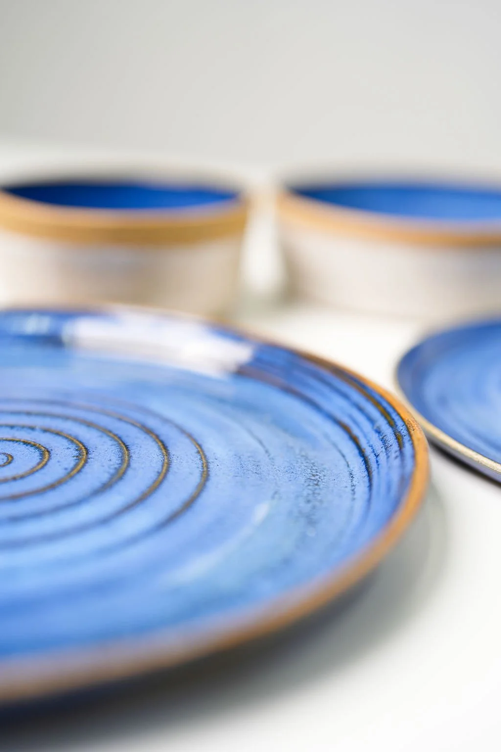 Close-up of blue and gold ceramic plates with spiral and circular designs.