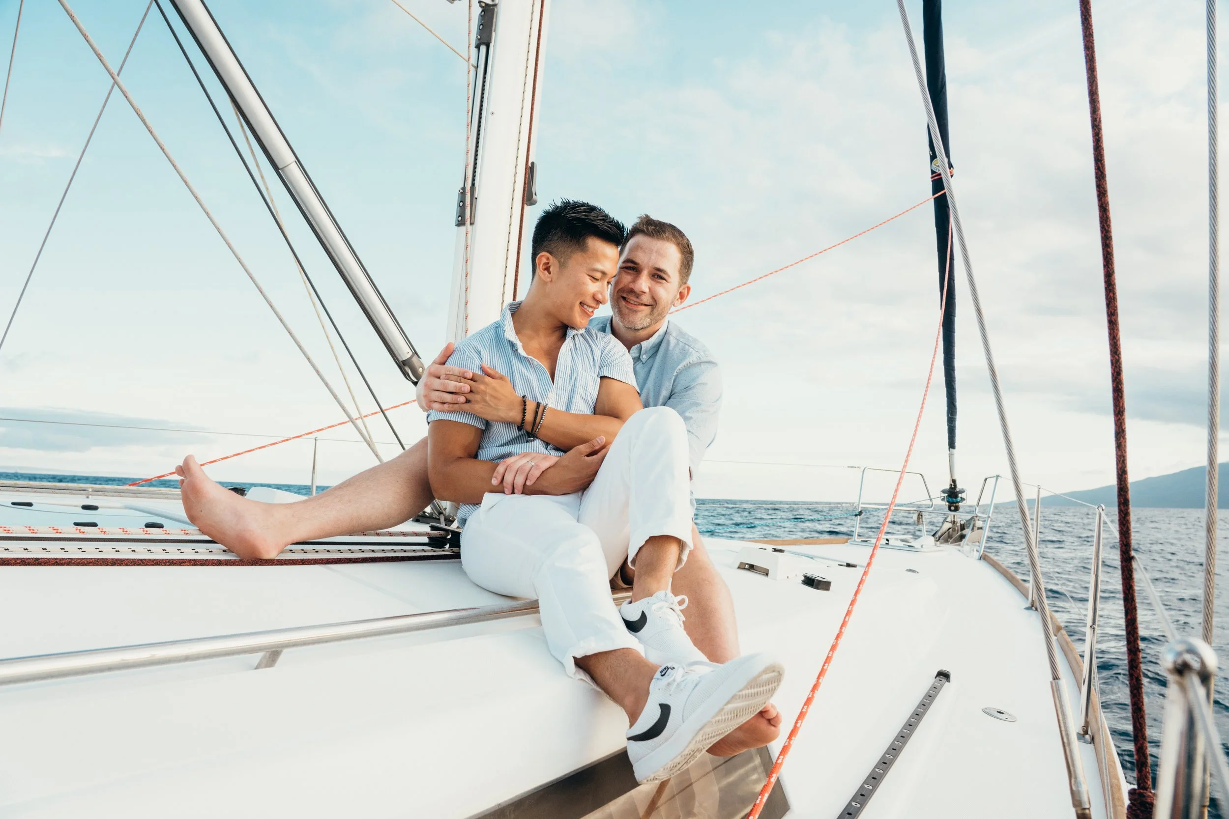 This queer engagement moment captures a same-sex couple celebrating on a sailboat in open water. The interaction is candid and emotionally grounded. The photographer is based in Colorado, serving LGBTQ+ couples across Denver, Vail, and Rocky Mountain