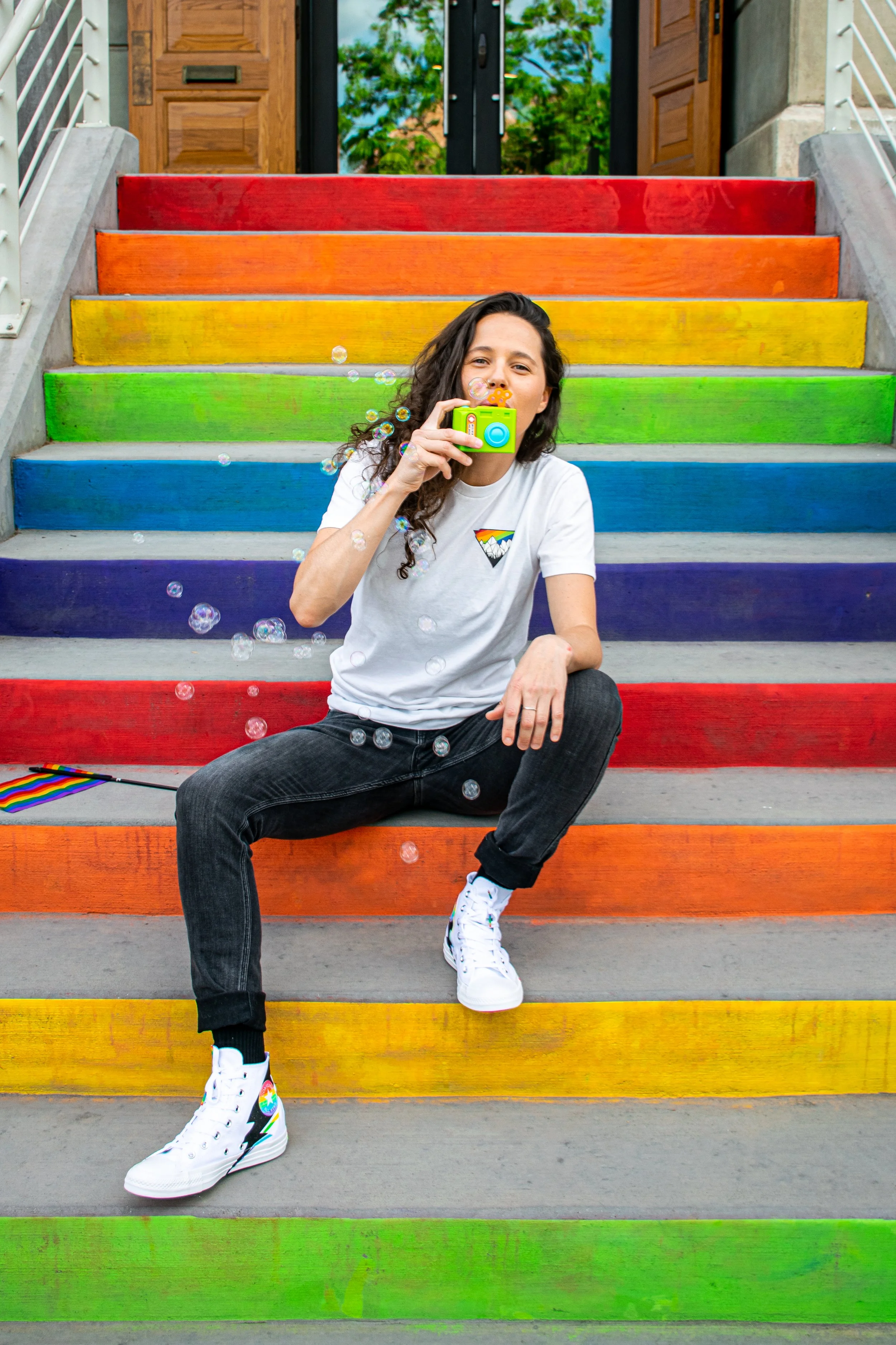 Photographer Rachael participating in a Pride event celebrating LGBTQ+ community and visibility. Wild Queer Free proudly serves queer couples, families, and businesses throughout Colorado. Award-winning photojournalist Rachael documenting community s
