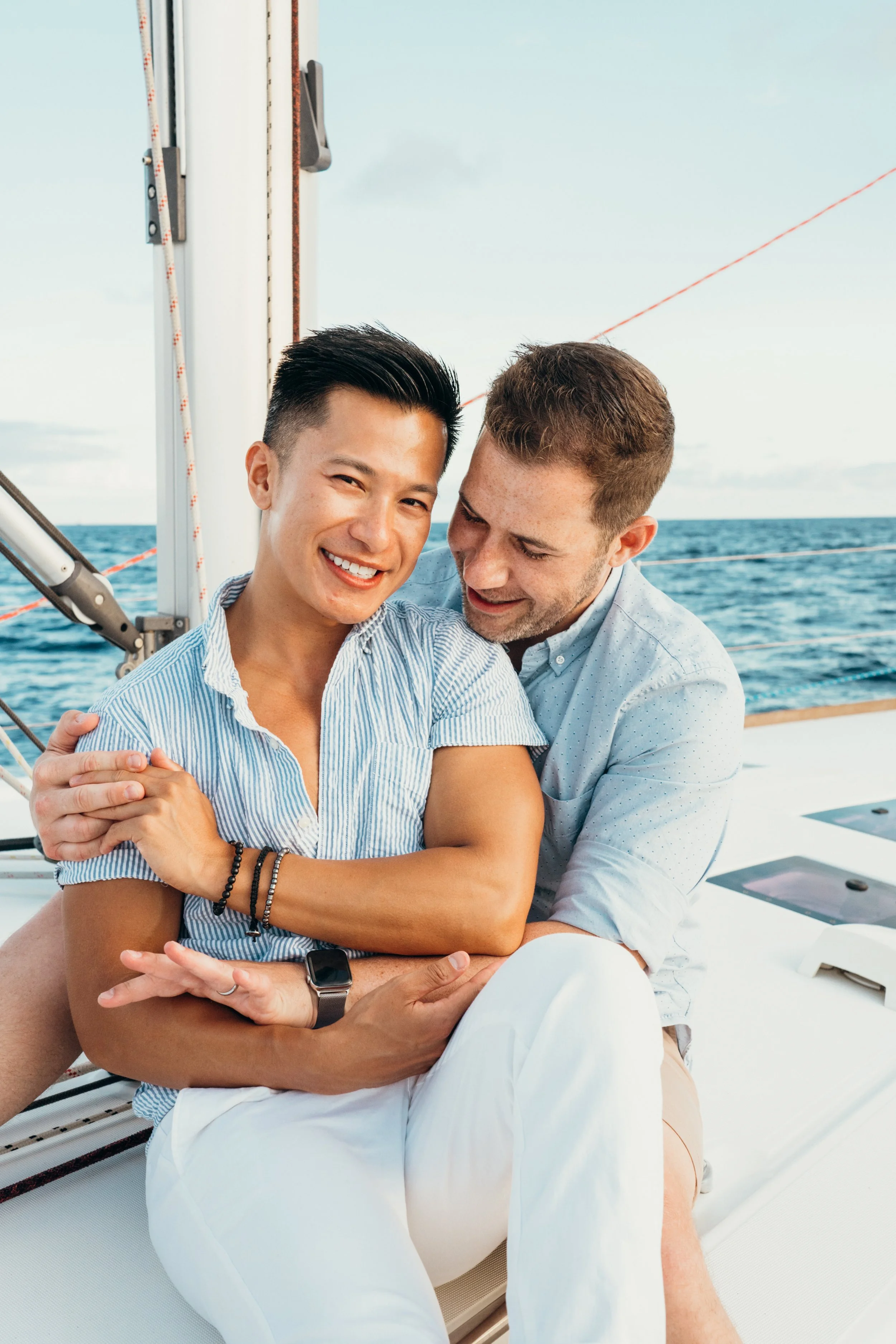A queer same-sex sailboat proposal captures a gay couple in a natural ocean environment. The couple shares an emotional reaction after the engagement. This photography is rooted in Colorado-based elopement storytelling and adventure work. The brand s