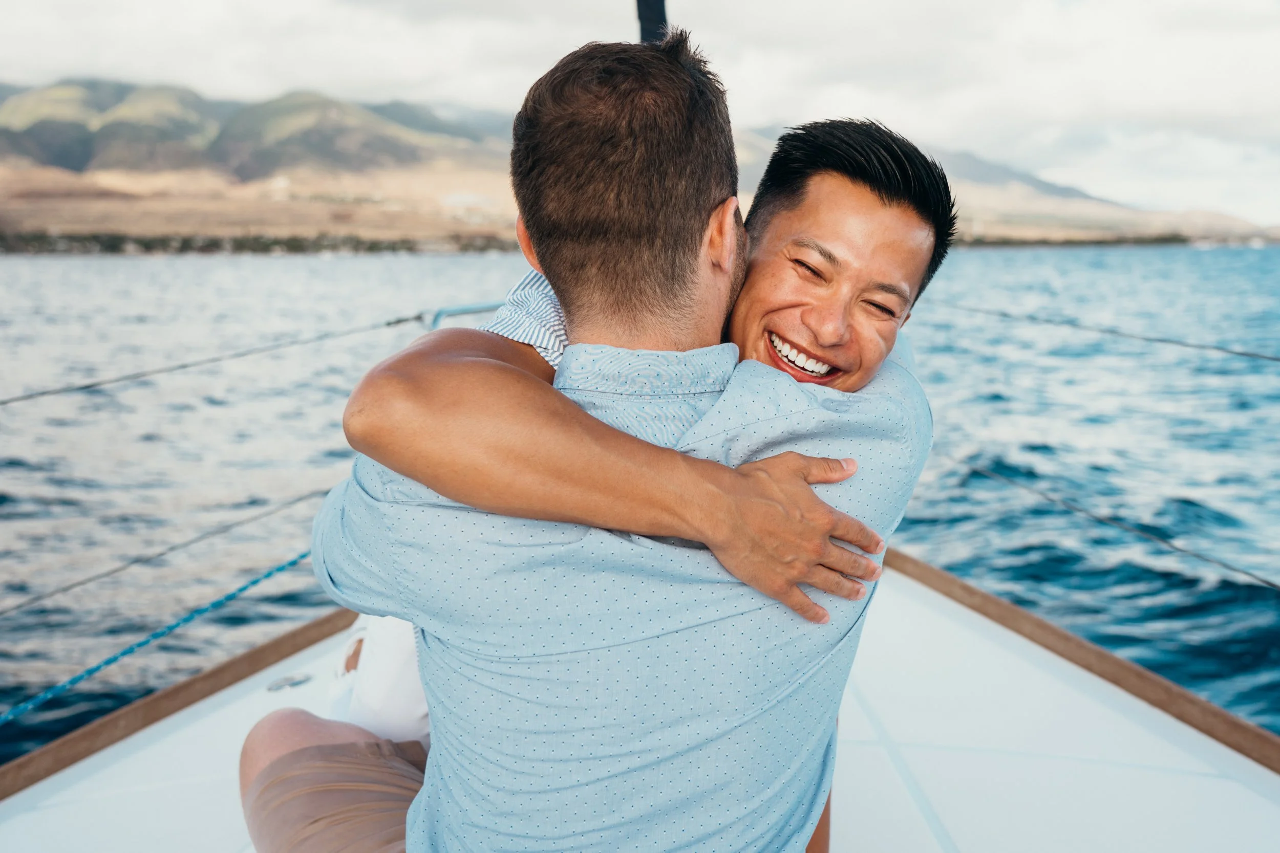 A lesbian engagement proposal unfolds on a sailboat with wind and ocean movement creating natural emotion. The couple shares an intimate queer celebration after the engagement. This LGBTQ+ photography brand is rooted in Colorado elopement storytellin