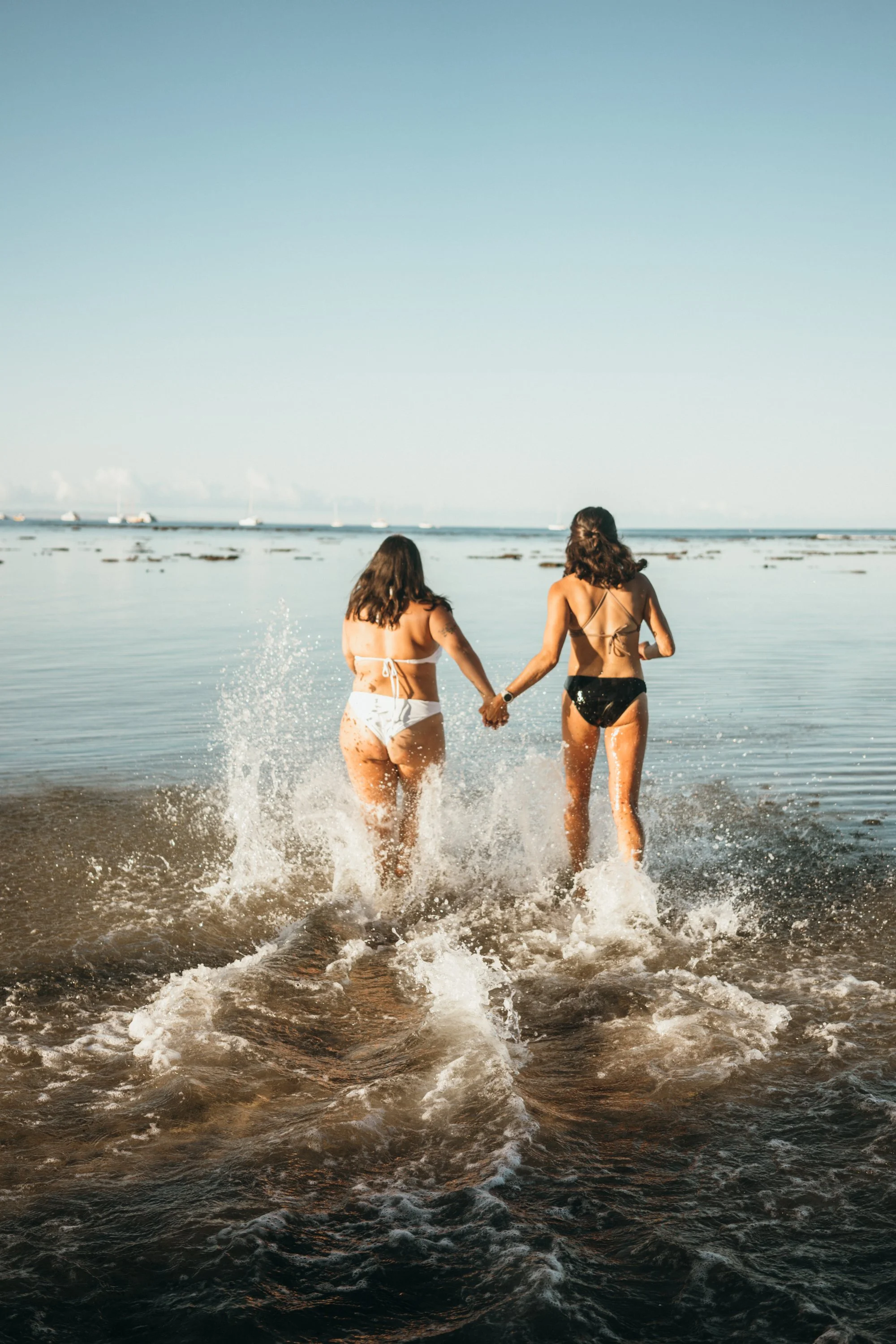 A romantic engagement proposal on a beach is documented in soft early morning light. The couple stands together near the water in a quiet emotional moment. The composition emphasizes natural storytelling and authenticity. This image is part of a Colo