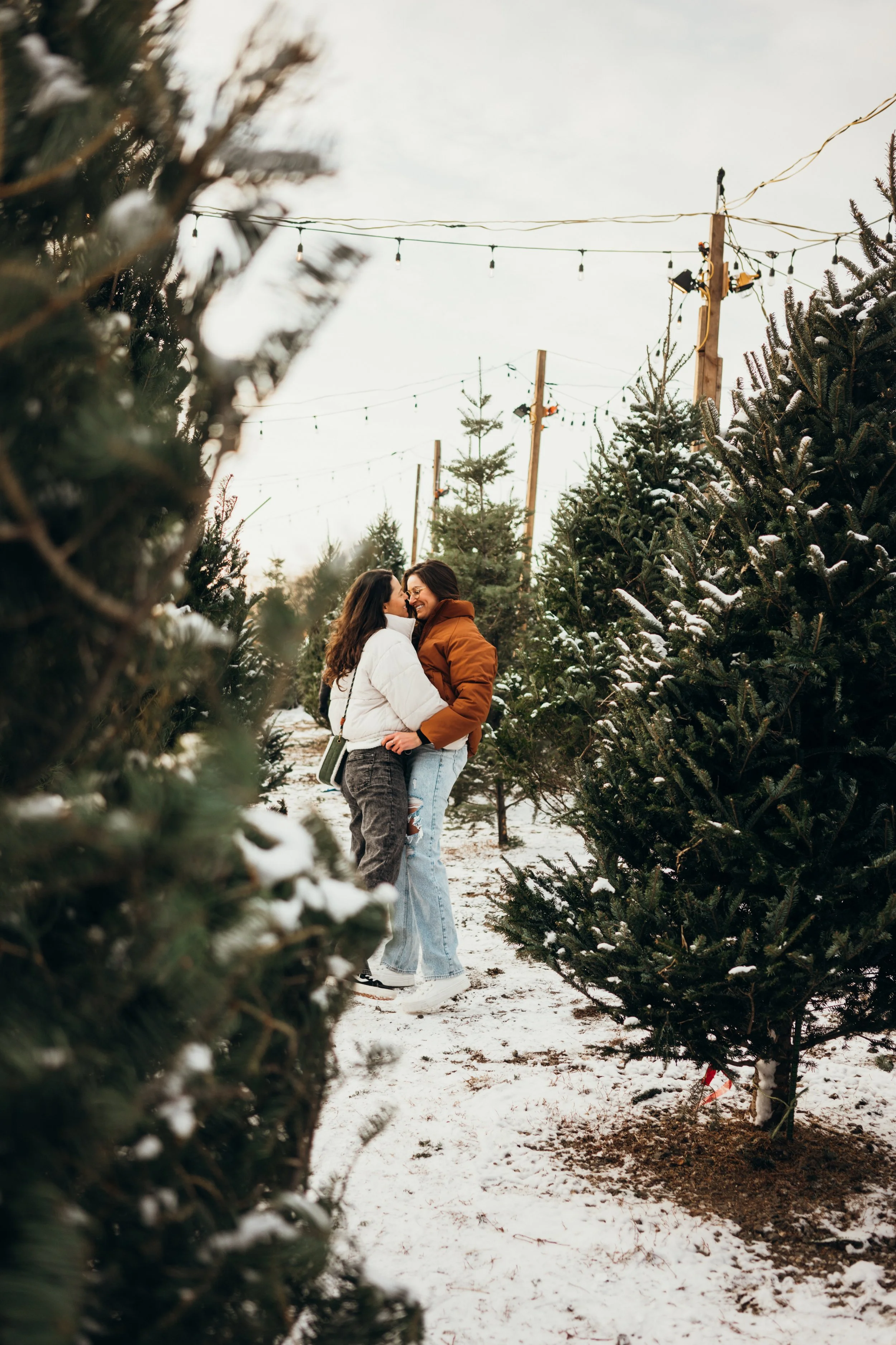 A romantic winter engagement unfolds after a snowboard descent in a Colorado mountain setting. The couple is framed against expansive alpine scenery and snow-covered peaks. This work reflects a queer Colorado-based elopement photographer specializing