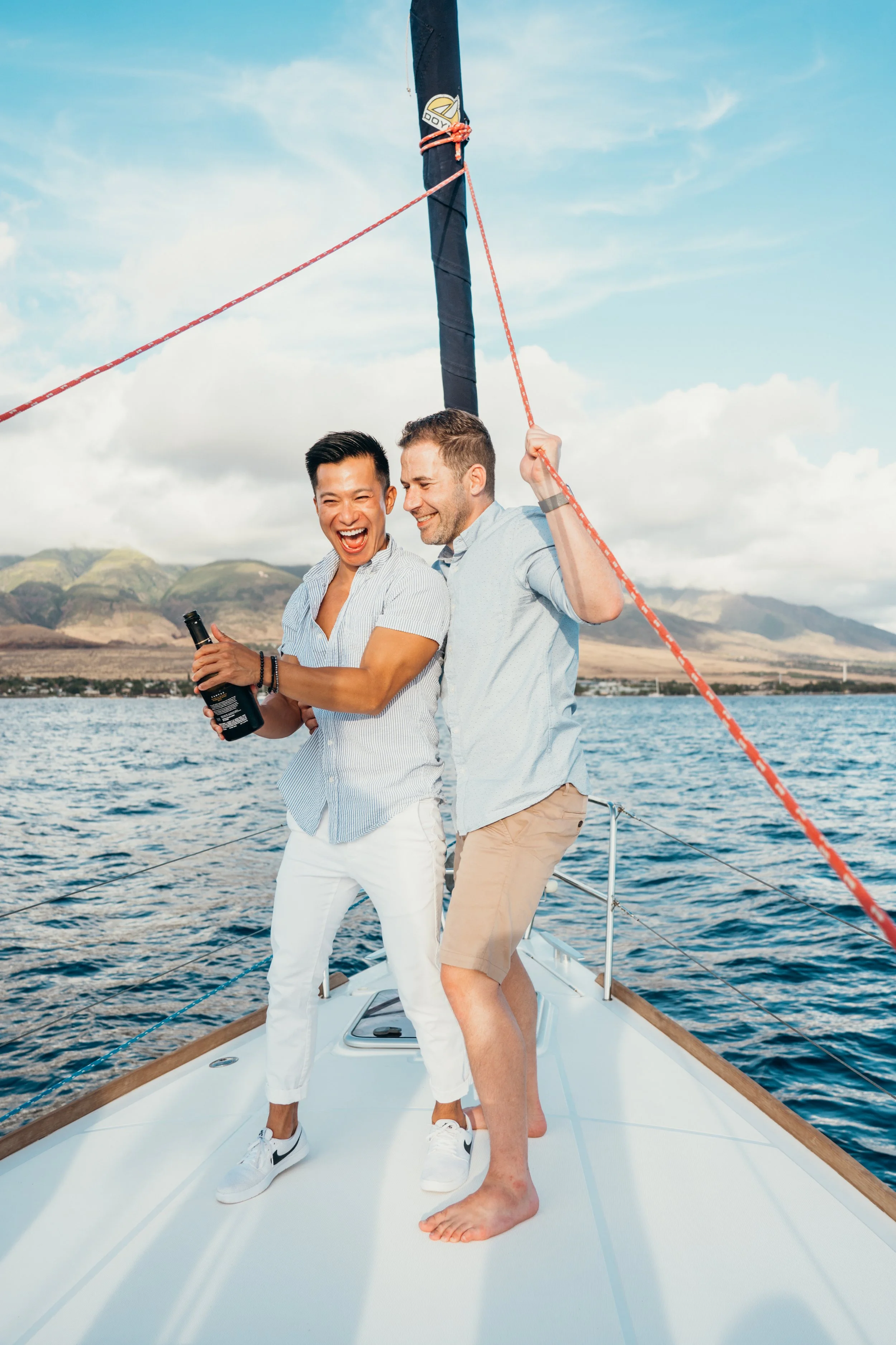 This LGBTQ+ sailboat engagement session documents a lesbian couple in an intimate ocean setting. The wind and water create a cinematic atmosphere around the couple. The photographer specializes in queer elopements across Denver and Rocky Mountain lan