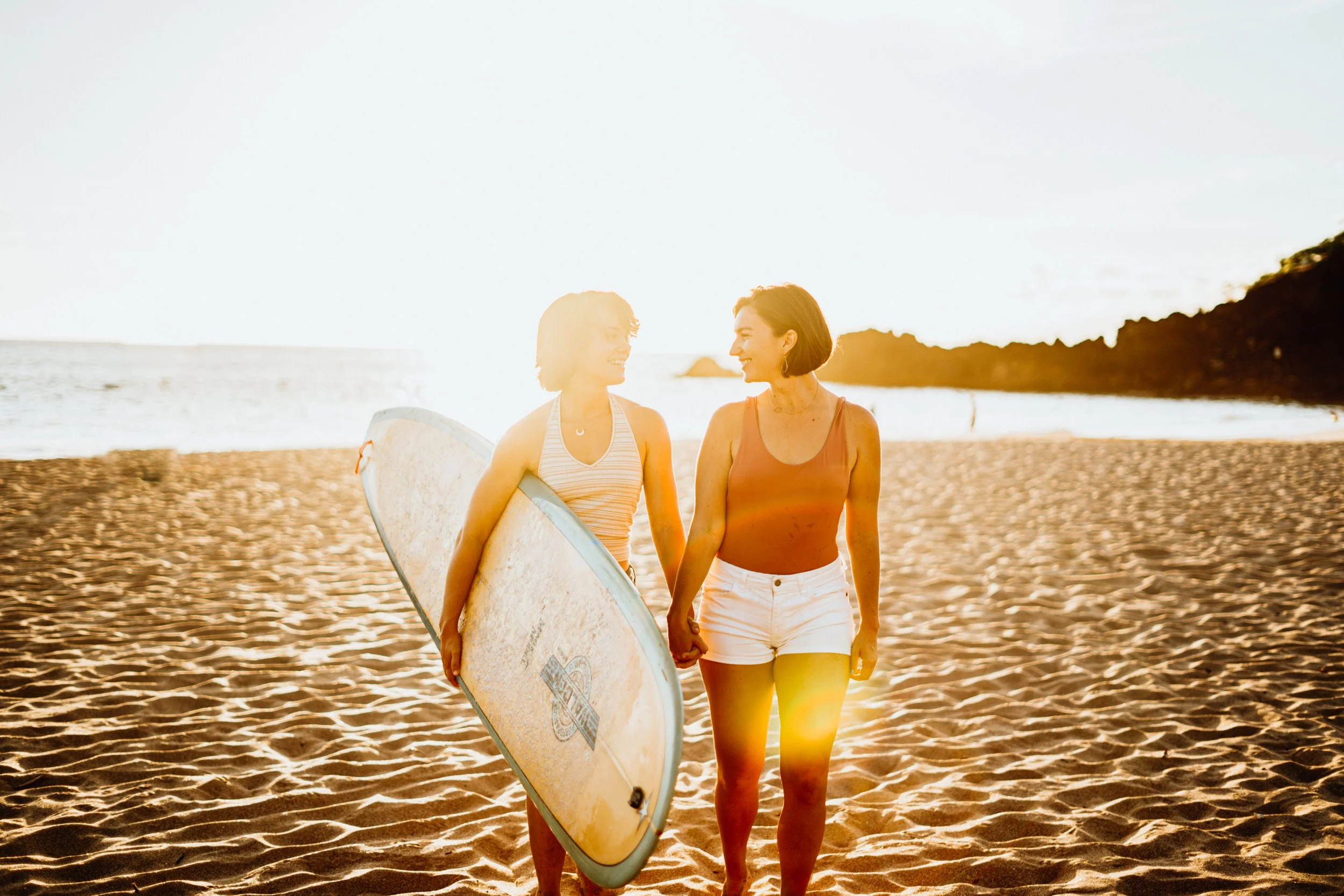 A lesbian couple engagement-style surf session shows queer love in ocean waves. The interaction is candid and emotionally driven. This Colorado-based elopement photographer serves gay, lesbian, and queer couples across Rocky Mountain regions. The sto