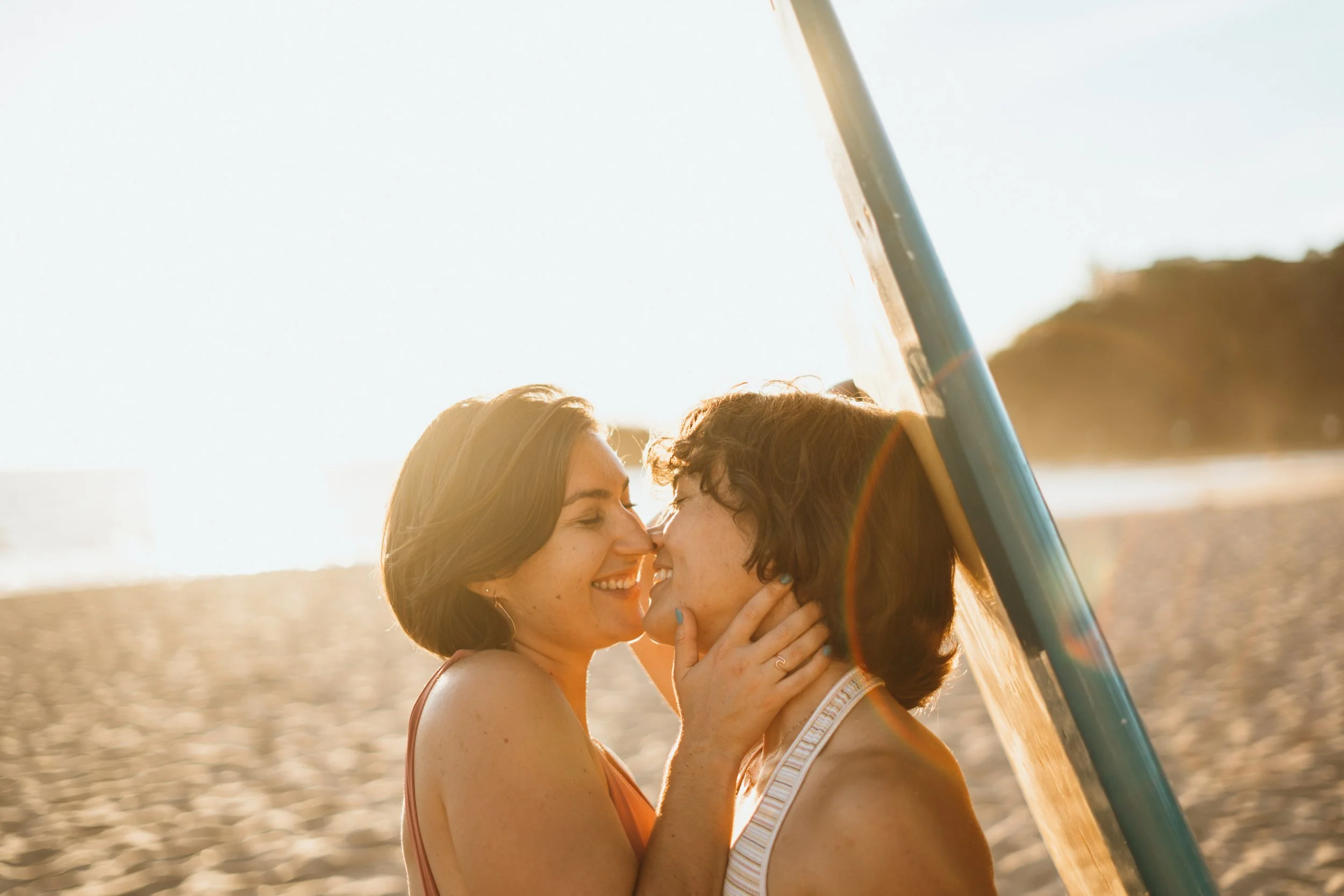 This queer engagement-style surf session documents a lesbian couple interacting in ocean waves. The environment is natural and expressive, emphasizing real emotion. The photographer specializes in LGBTQ+ elopements across Colorado, including Boulder 