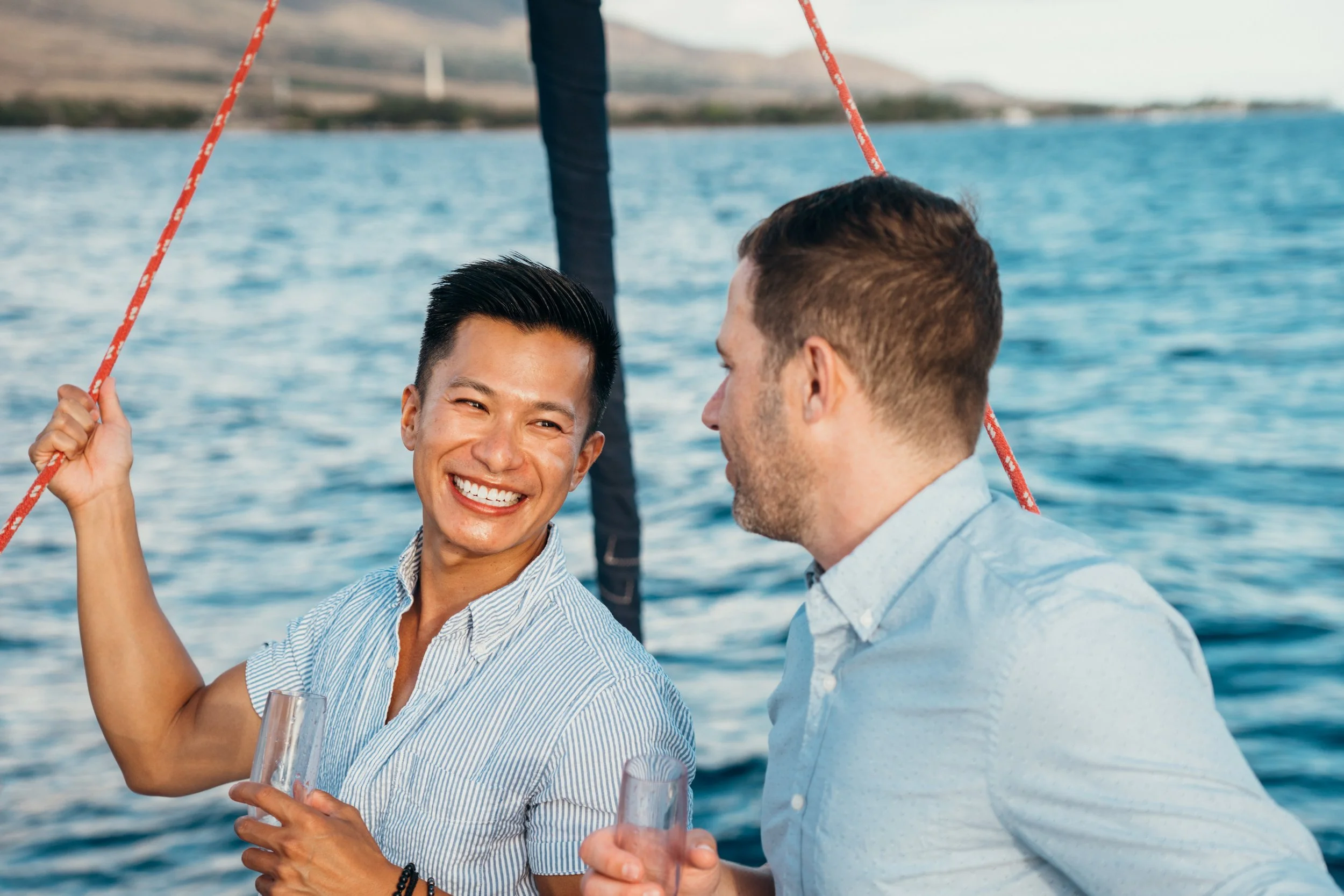 A gay engagement proposal unfolds on a sailboat with soft natural lighting and open sea. The couple shares a queer moment of celebration and connection. This Colorado-based photographer focuses on LGBTQ+ elopements across Evergreen and Boulder foothi