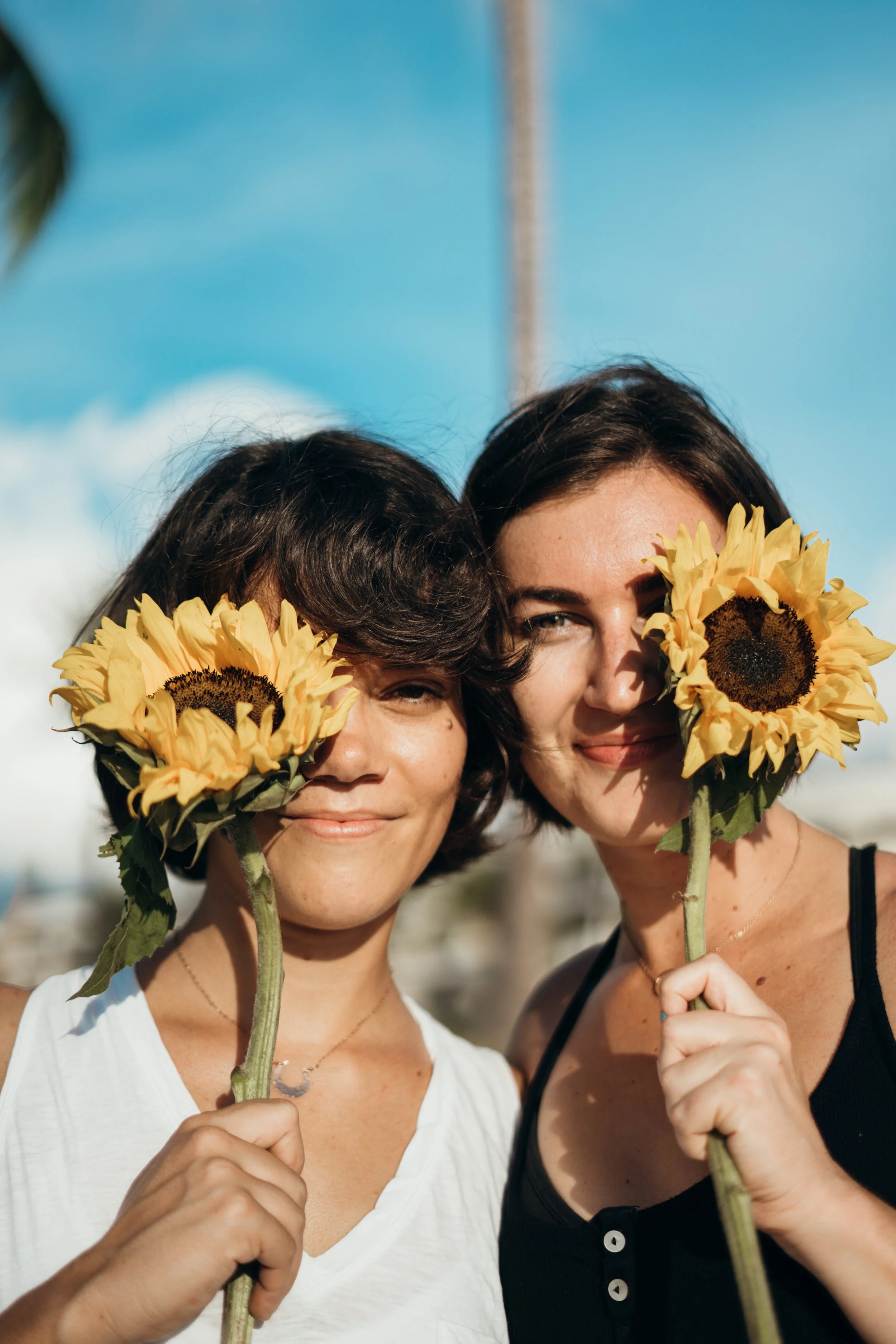 A same-sex queer couple shares a playful surf session in ocean water with natural light. The interaction is candid and emotionally expressive. This Colorado-based elopement photographer serves gay and lesbian couples across Rocky Mountain and Denver 