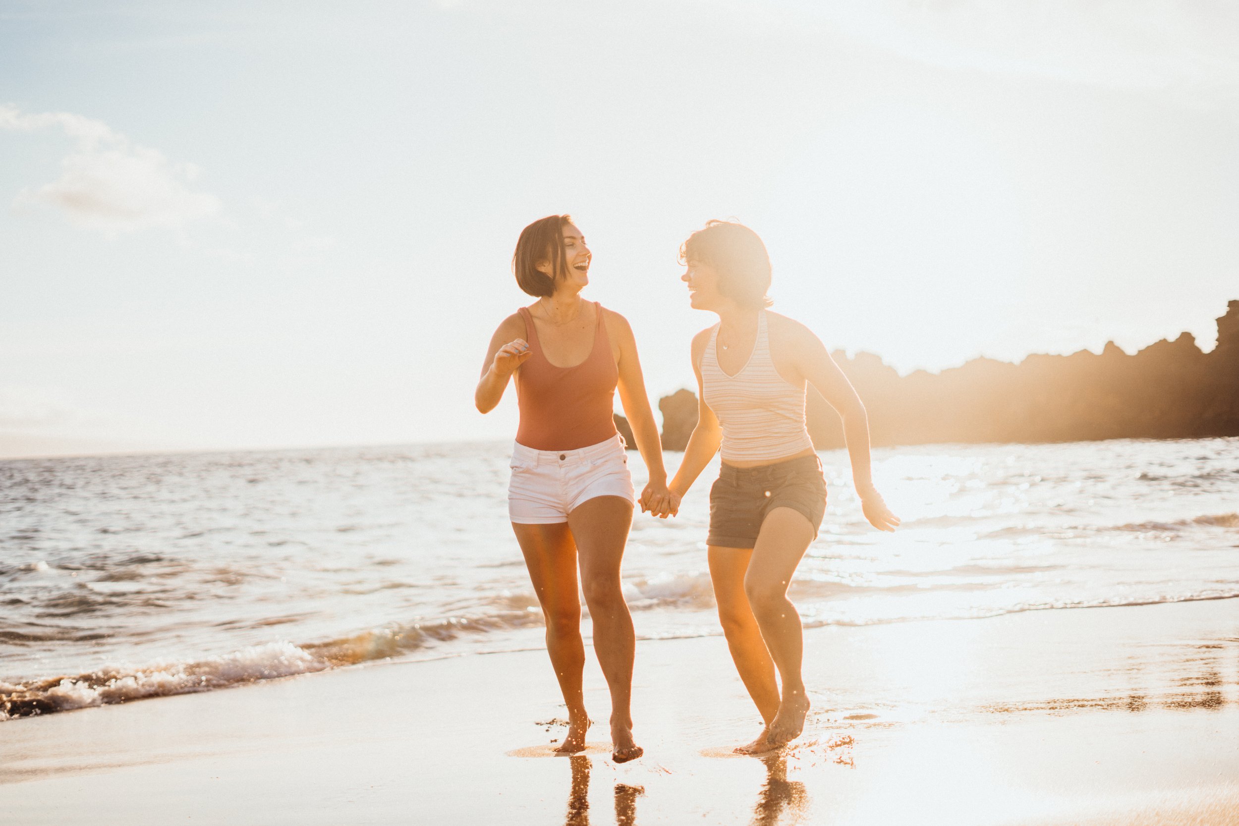 This queer surf engagement session captures a gay couple in ocean water with natural motion. The environment enhances emotional storytelling and connection. The photographer specializes in LGBTQ+ elopements across Colorado landscapes including Boulde