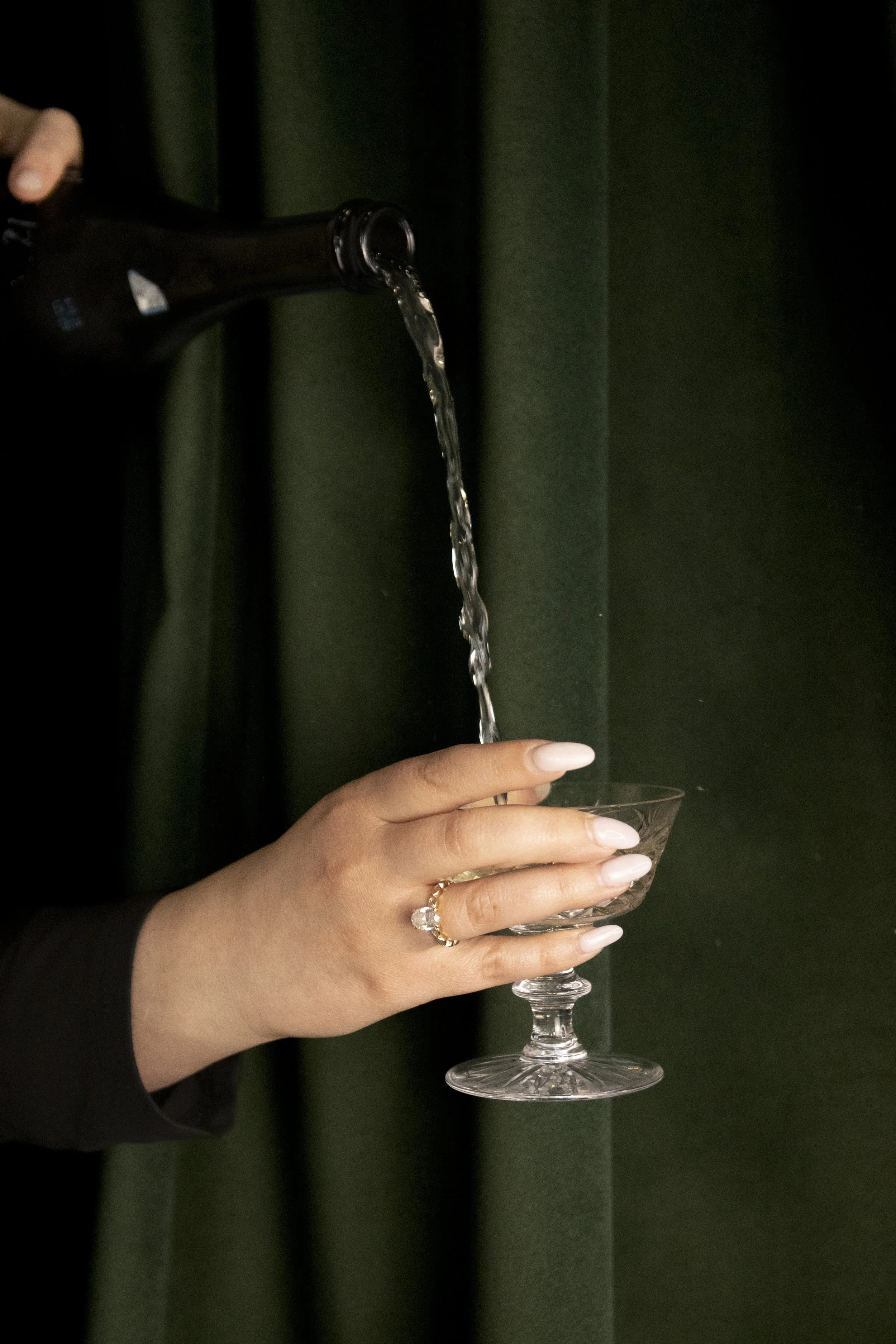 Person pouring a drink into a glass.