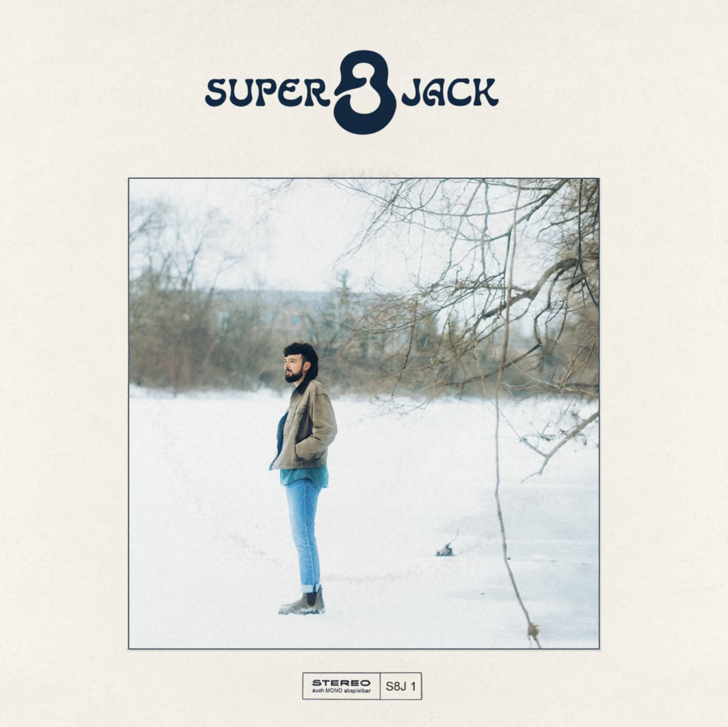 Cover image for "Super 8 Jack" album with a man standing in a snow-covered landscape under a tree with bare branches, wearing a beige jacket, blue jeans, and ice skates.
