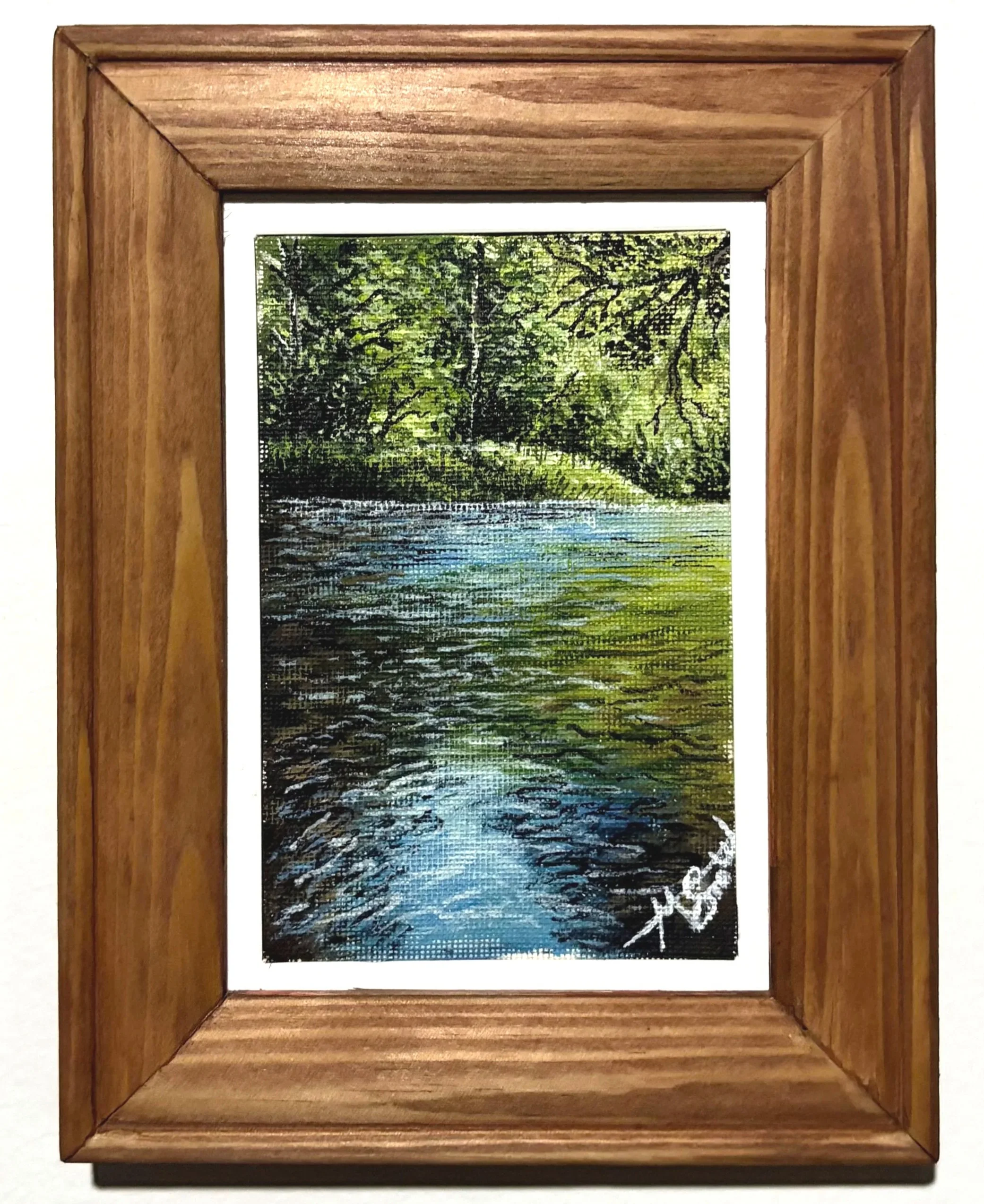 A wooden picture frame surrounding a painting of a green, leafy forest with a calm river flowing through.