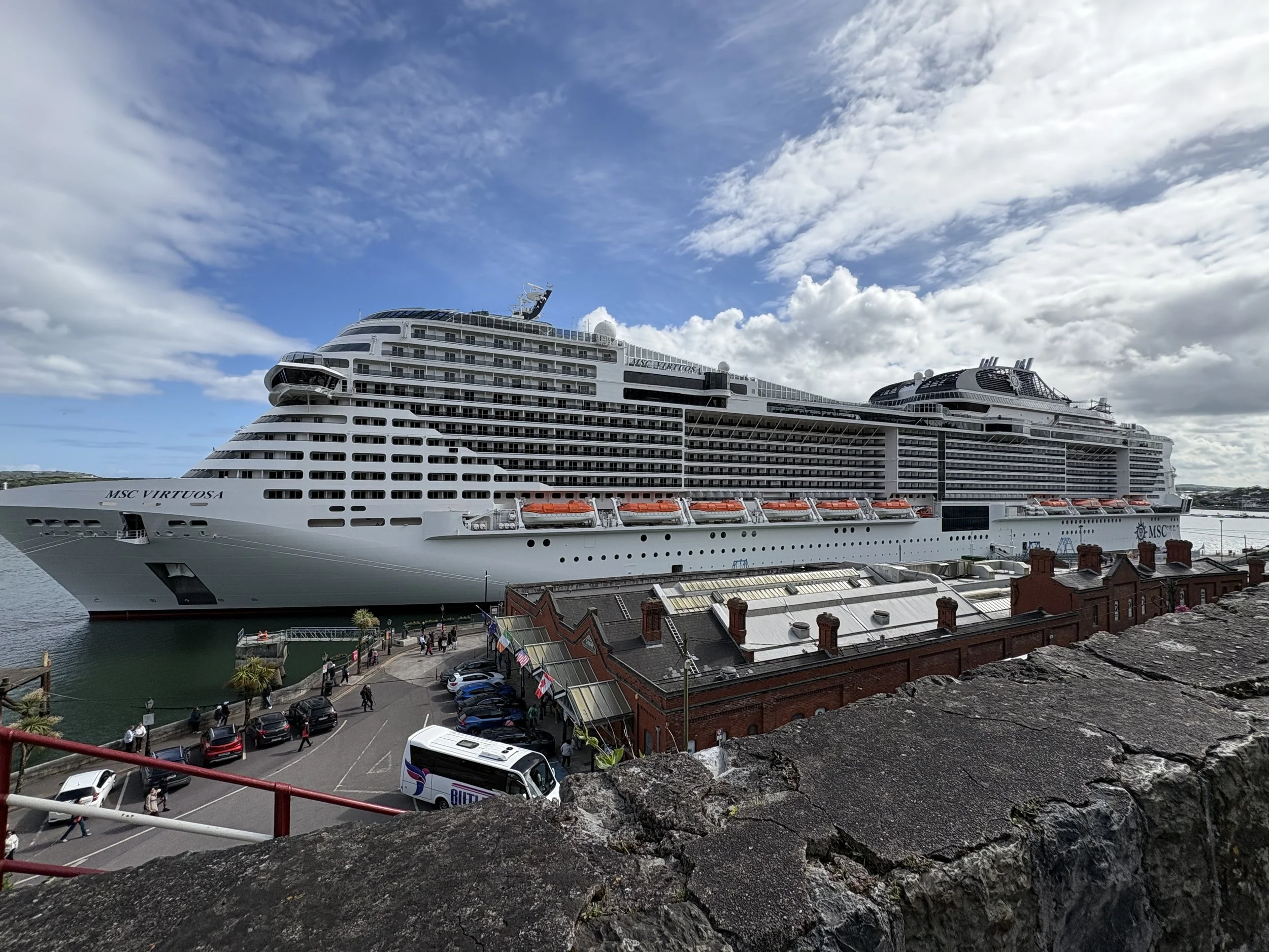 MSC Virtuosa docked in Cobh in front of the Heritage Visitor Center and the Cobh railway station